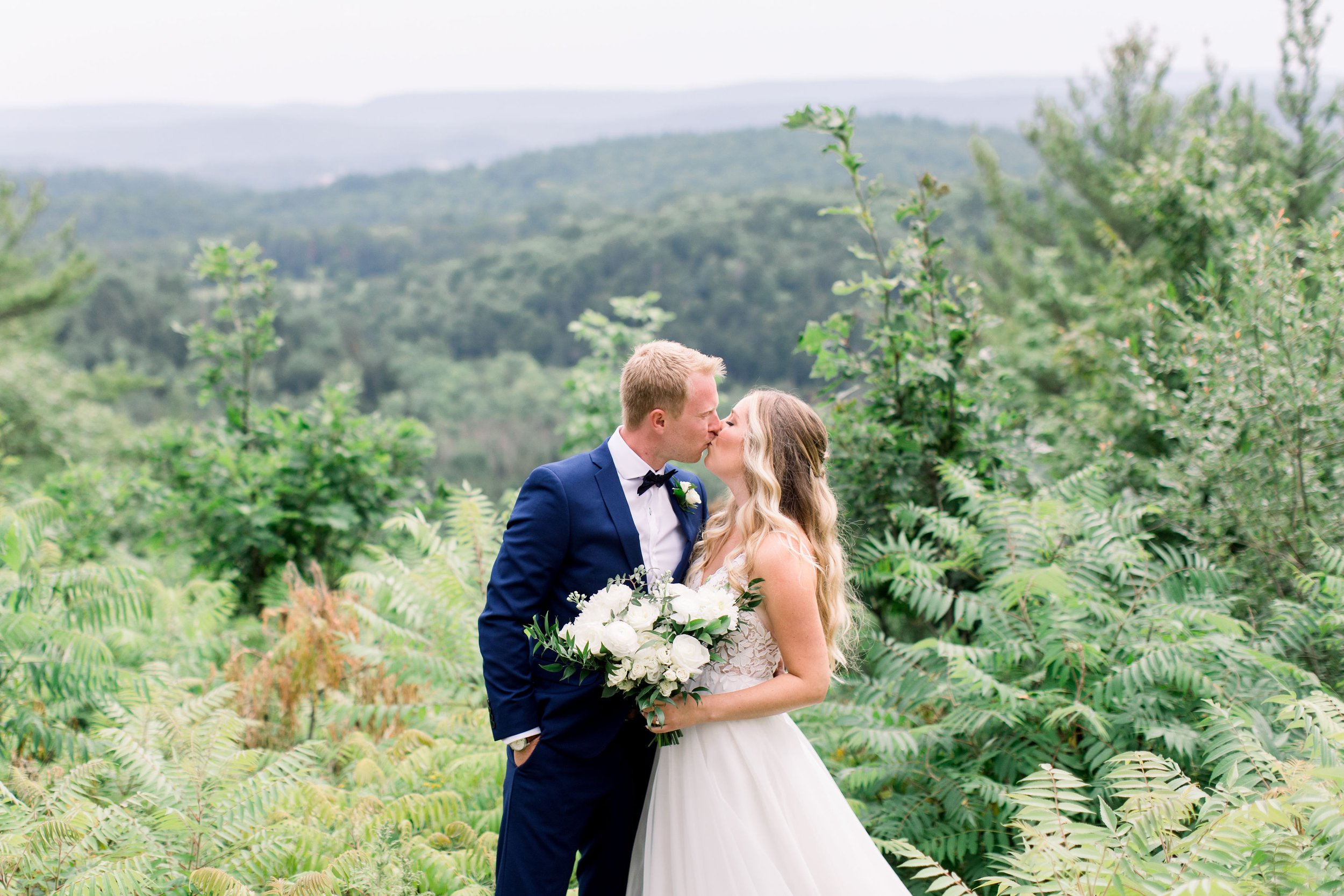  Bride and groom kiss with beautiful Quebec greenery behind them captured by Chelsea Mason Photography. Quebec wedding locations #Quebecweddings #elegantoutdoorwedding #Quebecweddingphotographers #Chelseamasonphotography #Chelseamasonweddings 