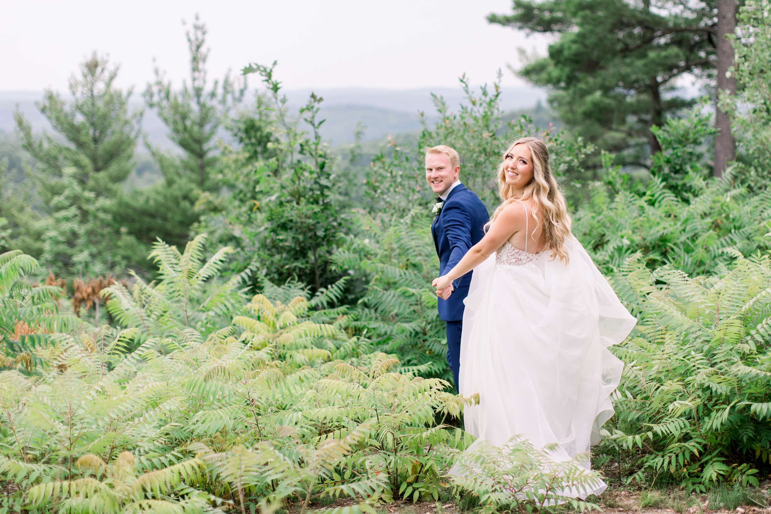  Chelsea Mason Photography captures a bride and groom escaping on an outdoor path on their wedding day. outdoor wedding portraits #Quebecweddings #elegantoutdoorwedding #Quebecweddingphotographers #Chelseamasonphotography #Chelseamasonweddings 