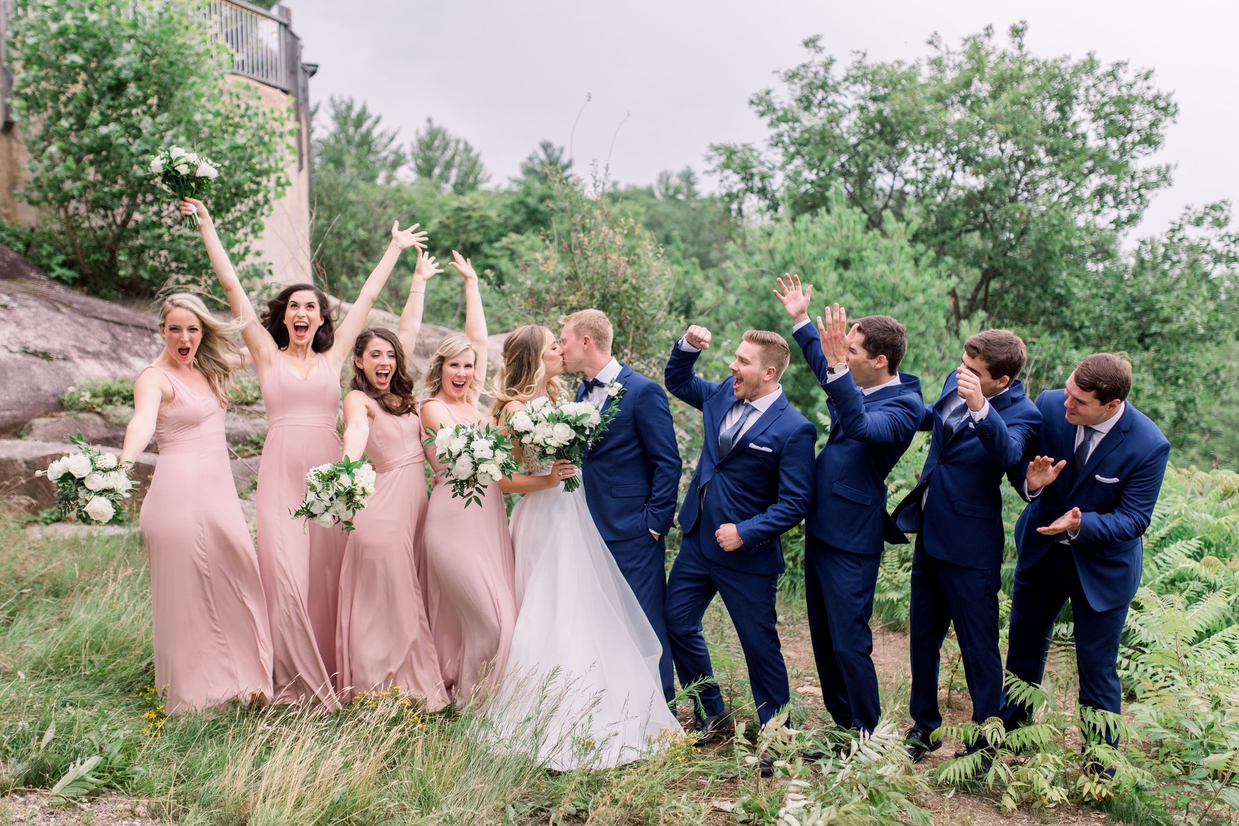  Bridesmaids and groomsmen in Wakefield cheer as the bride and groom kiss by Chelsea Mason Photography. Le Belevedere weddings #Quebecweddings #elegantoutdoorwedding #Quebecweddingphotographers #Chelseamasonphotography #Chelseamasonweddings 
