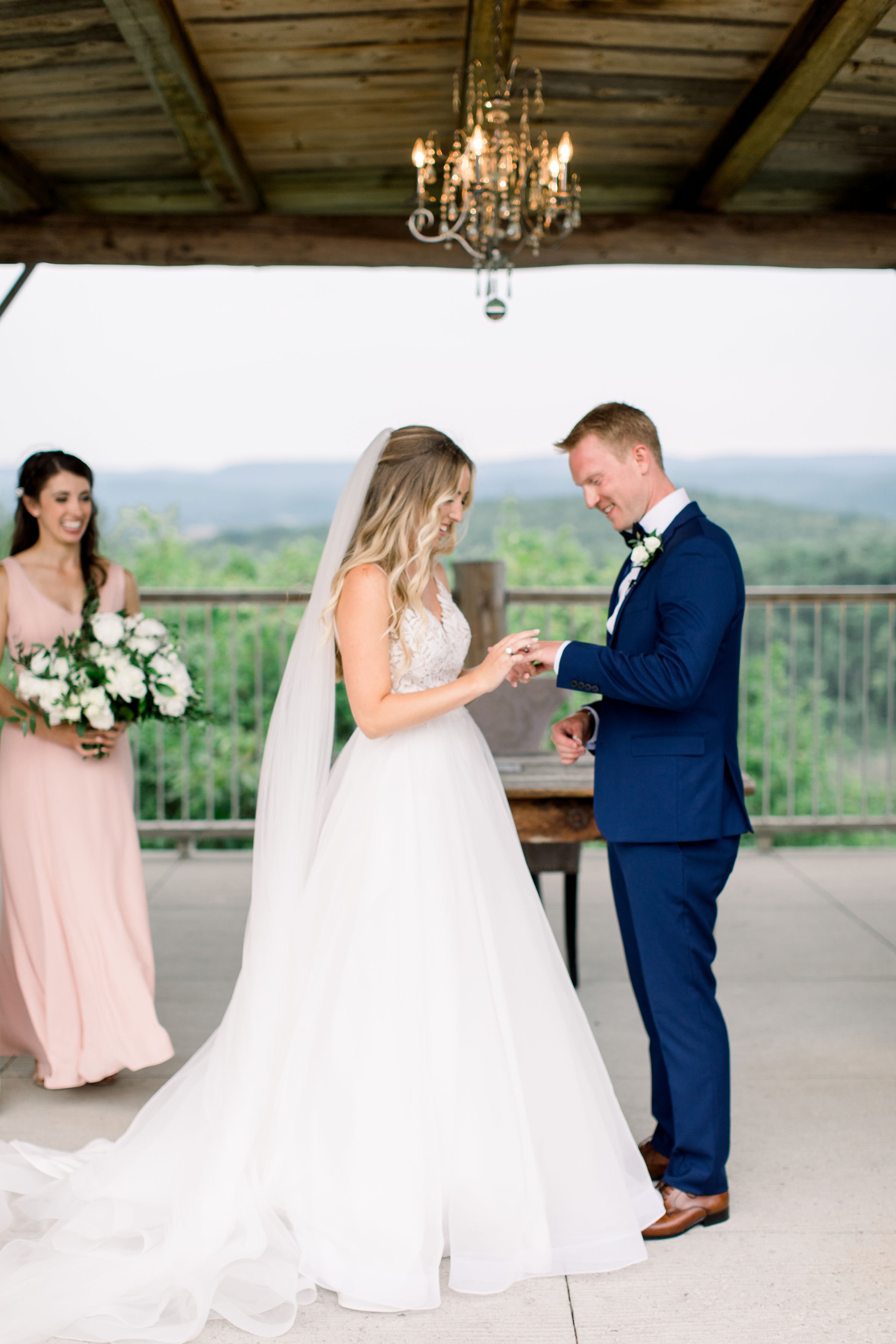  A bride places the ring onto the groom's finger during the ceremony by Chelsea Mason Photography. ring exchange til death do we part #Quebecweddings #elegantoutdoorwedding #Quebecweddingphotographers #Chelseamasonphotography #Chelseamasonweddings 