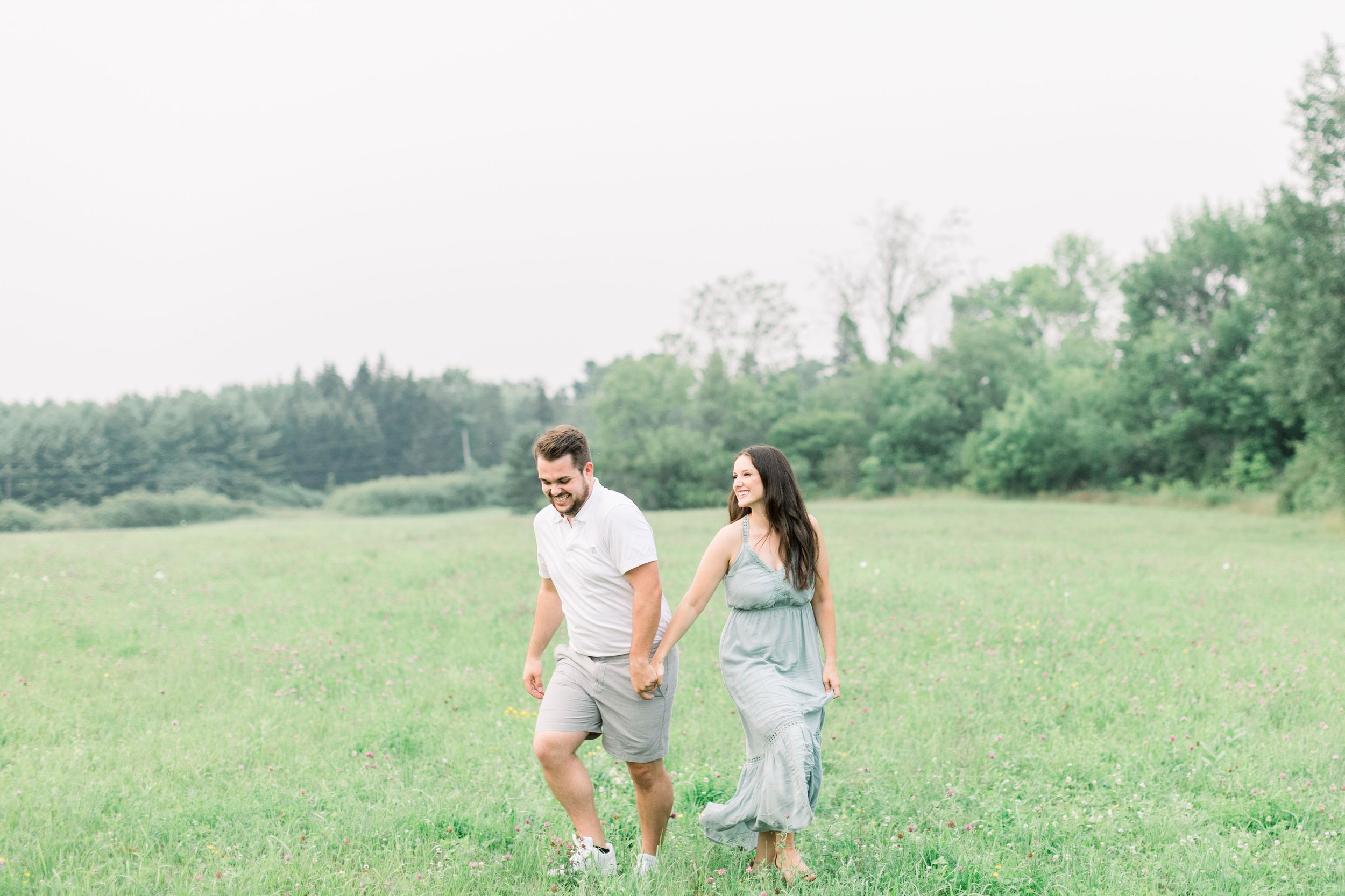  At Grass Creek Park an engaged couple runs through a field by Chelsea Mason Photography. frolic through field #Kingstonengagementlocations #GrassCreekParkPortraits #Ontarioengagementphotographers #Chelseamasonphotography #Chelseamasonengagements 
