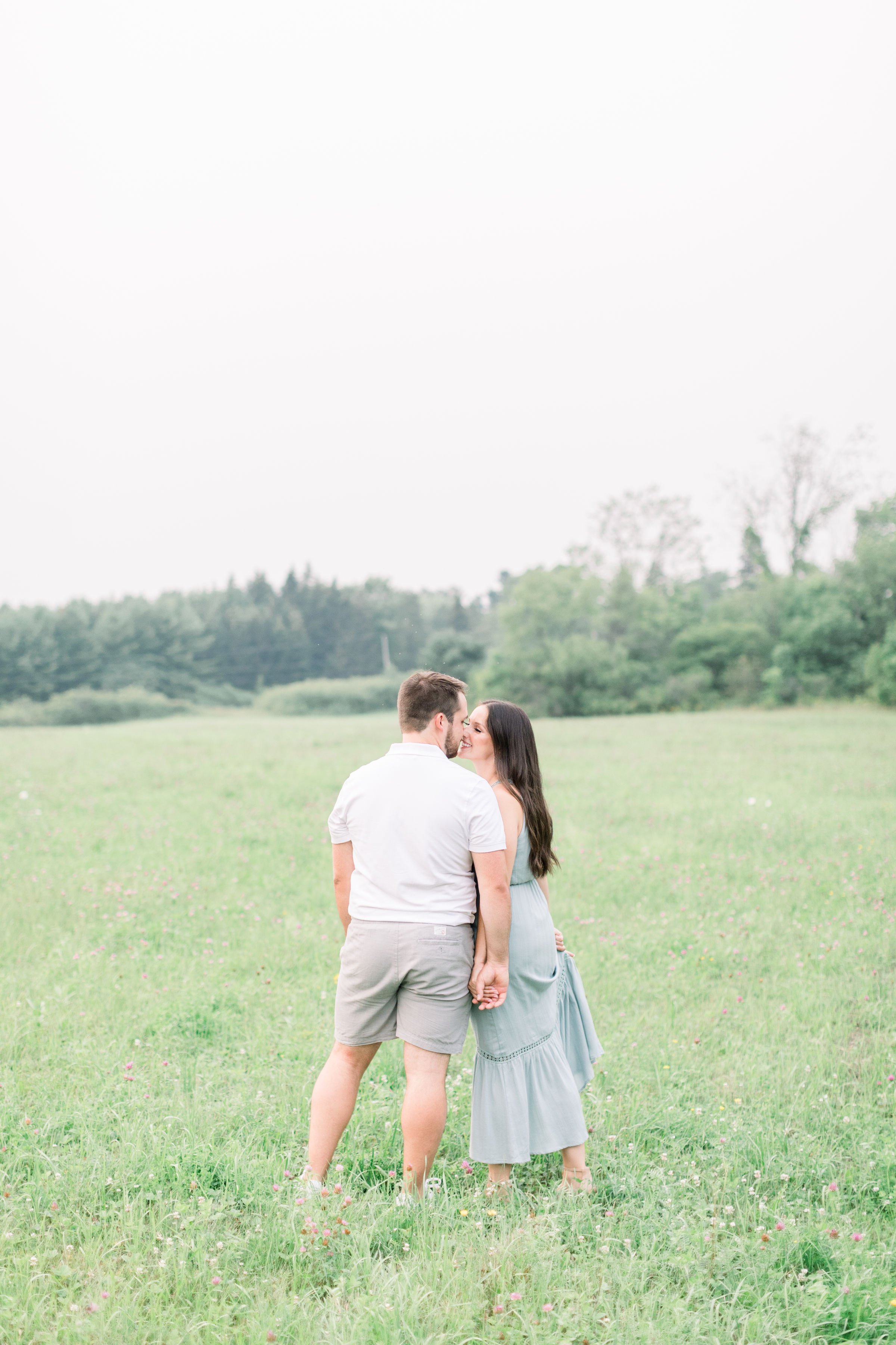  Chelsea Mason Photography captures a full-body portrait of partners kissing in Ontario. bright airy engagements Ontario #Kingstonengagement #GrassCreekParkPortraits #Ontarioengagementphotographers #Chelseamasonphotography #Chelseamasonengagements 