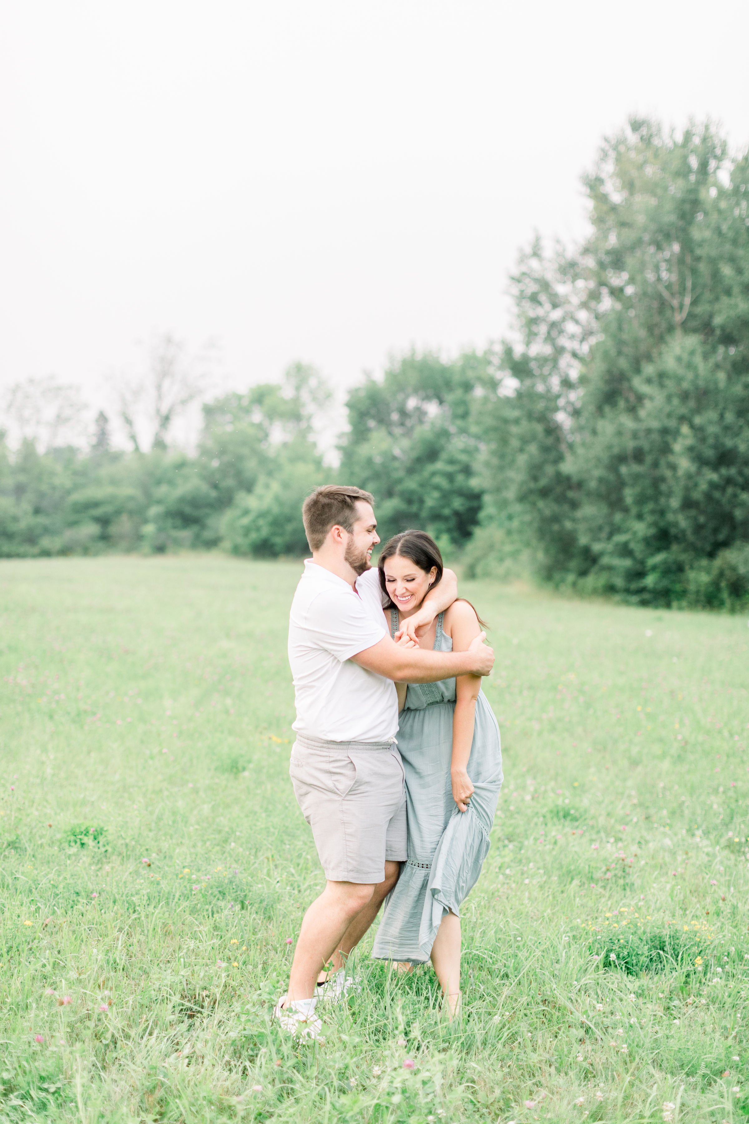  A man kisses the side of his fiances head captured by Chelsea Mason Photography. Kingston photographers engagements #Kingstonengagementlocations #GrassCreekParkPortraits #Ontarioengagementphotographers #Chelseamasonphotography #Chelseamasonengagemen