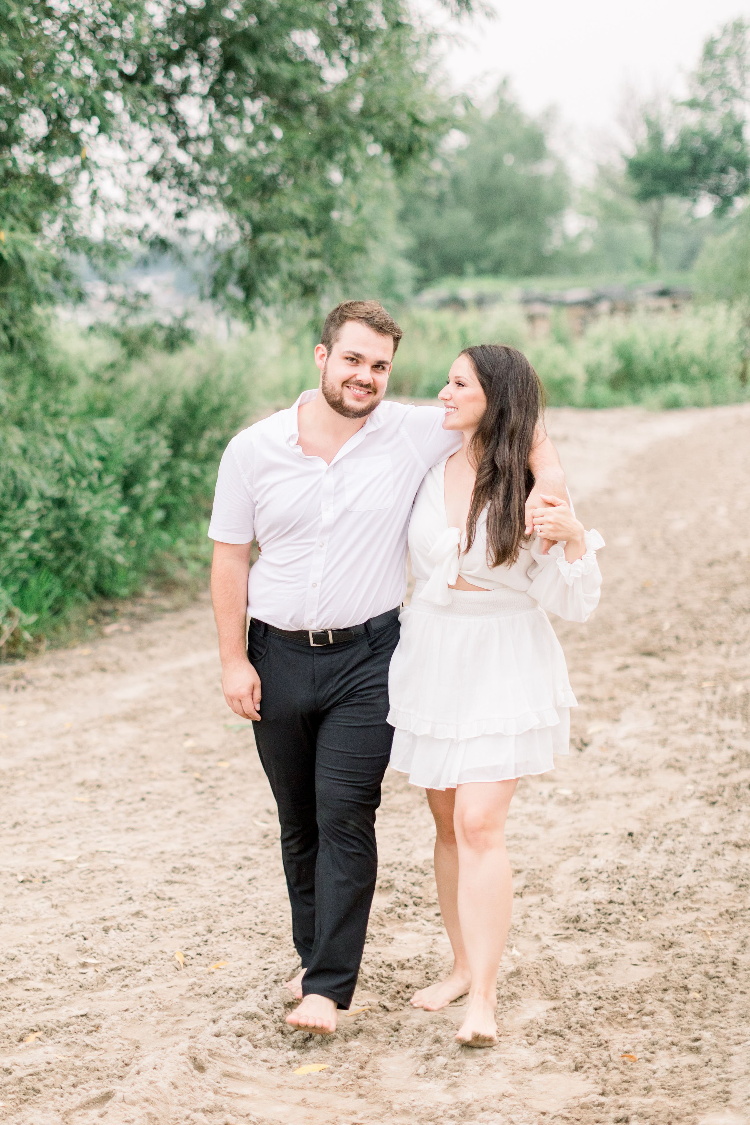  Wearing white an engaged couple enjoys each other's company in Kingston park by Chelsea Mason Photography. white outfits #Kingstonengagement #GrassCreekParkPortraits #Ontarioengagementphotographers #Chelseamasonphotography #Chelseamasonengagements 