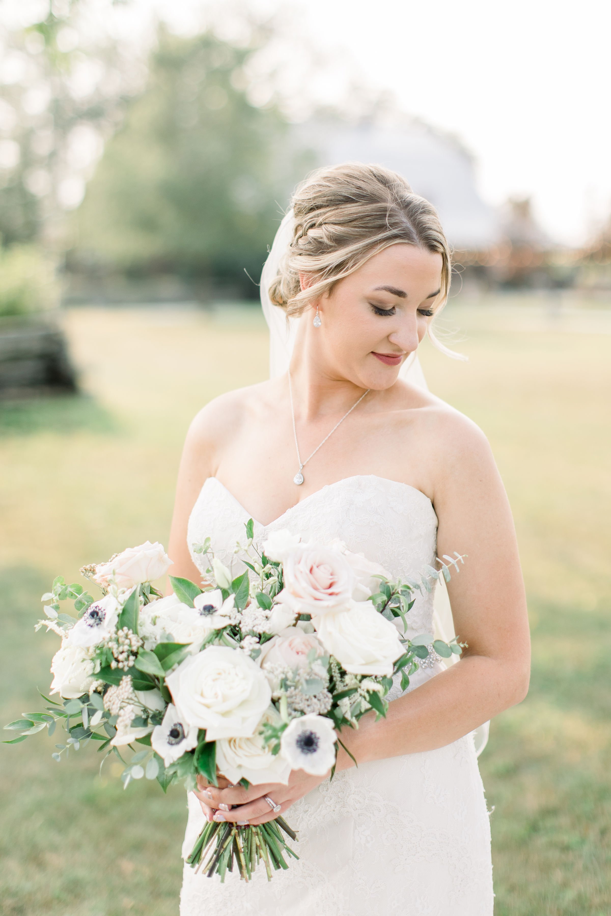  At an Ontario wedding, Chelsea Mason Photography captures a bride in a grass field looking down. summer wedding Ontario #StonefieldEstates #Ontarioweddings #Chelseamasonphotography #Chelseamasonengagements #Ontarioweddingphotographers 