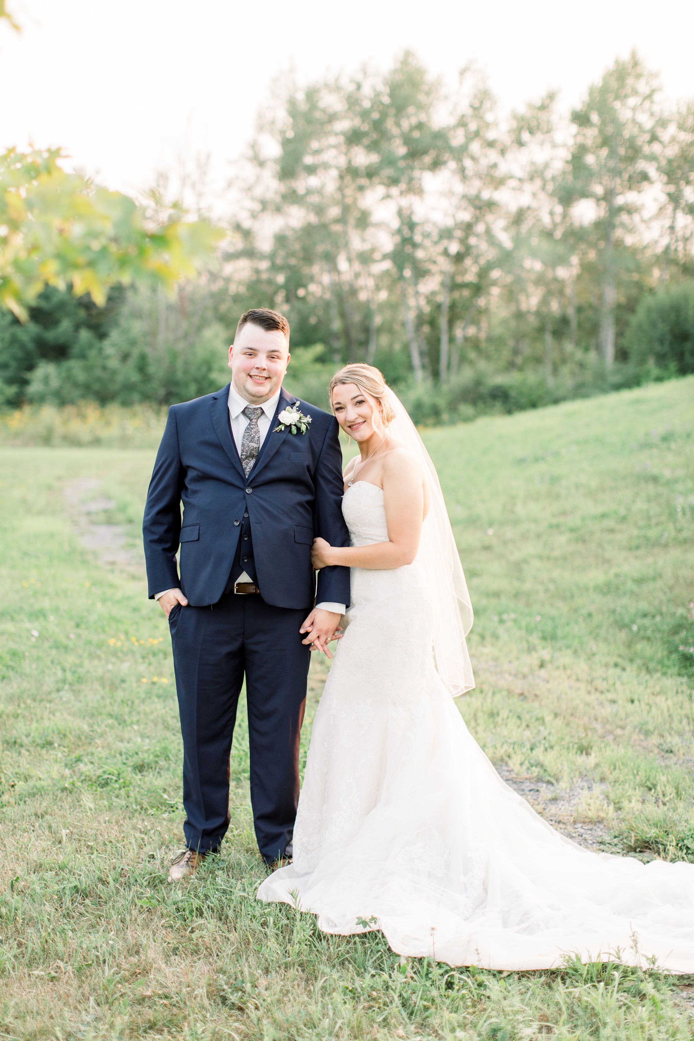  At a mountain location in Ontario, a bride and groom stand on a hillside together by Chelsea Mason Photography. bridal in mountain #StonefieldEstates #Ontarioweddings #Chelseamasonphotography #Chelseamasonengagements #Ontarioweddingphotographers 