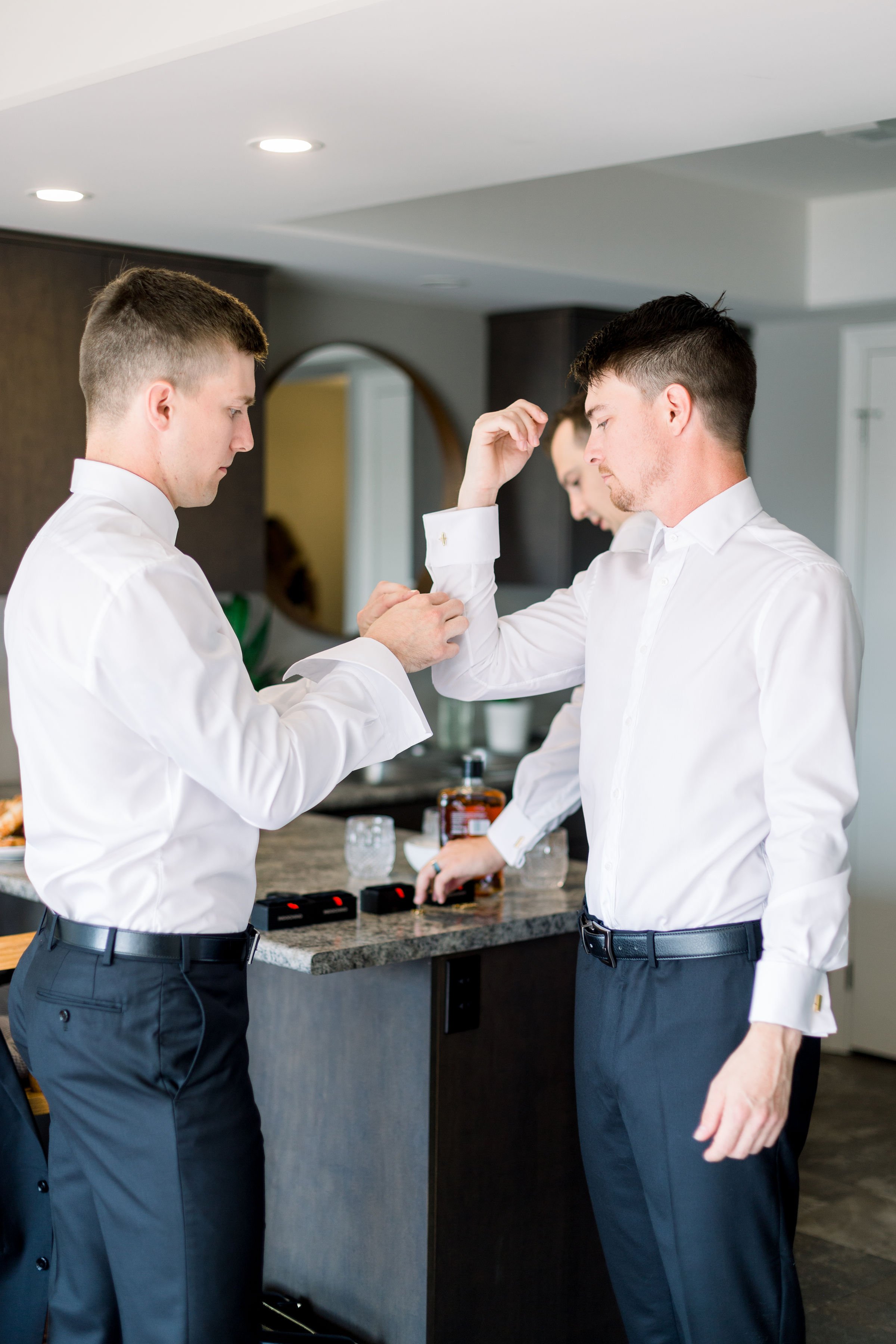  Chelsea Mason Photography captures the best man helping the groom with his cuff links. Sandbanks grooms best man helping groom #ChelseaMasonPhotography #ChelseaMasonWeddings #PrinceEdwardsCountryWeddings #SandbanksWeddings #ONweddingphotographer 