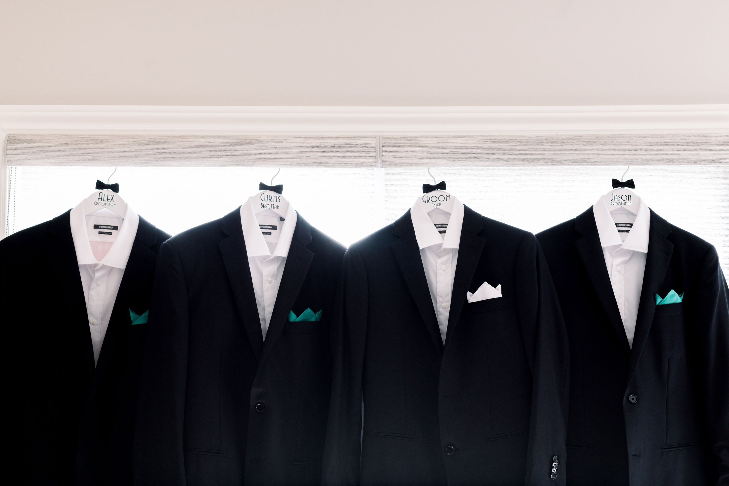  During a wedding in Sandbanks, ON Chelsea Mason Photography captures the suits hanging up in the doorway. suits hanging black suit #ChelseaMasonPhotography #ChelseaMasonWeddings #PrinceEdwardsCountryWeddings #SandbanksWeddings #ONweddingphotographer