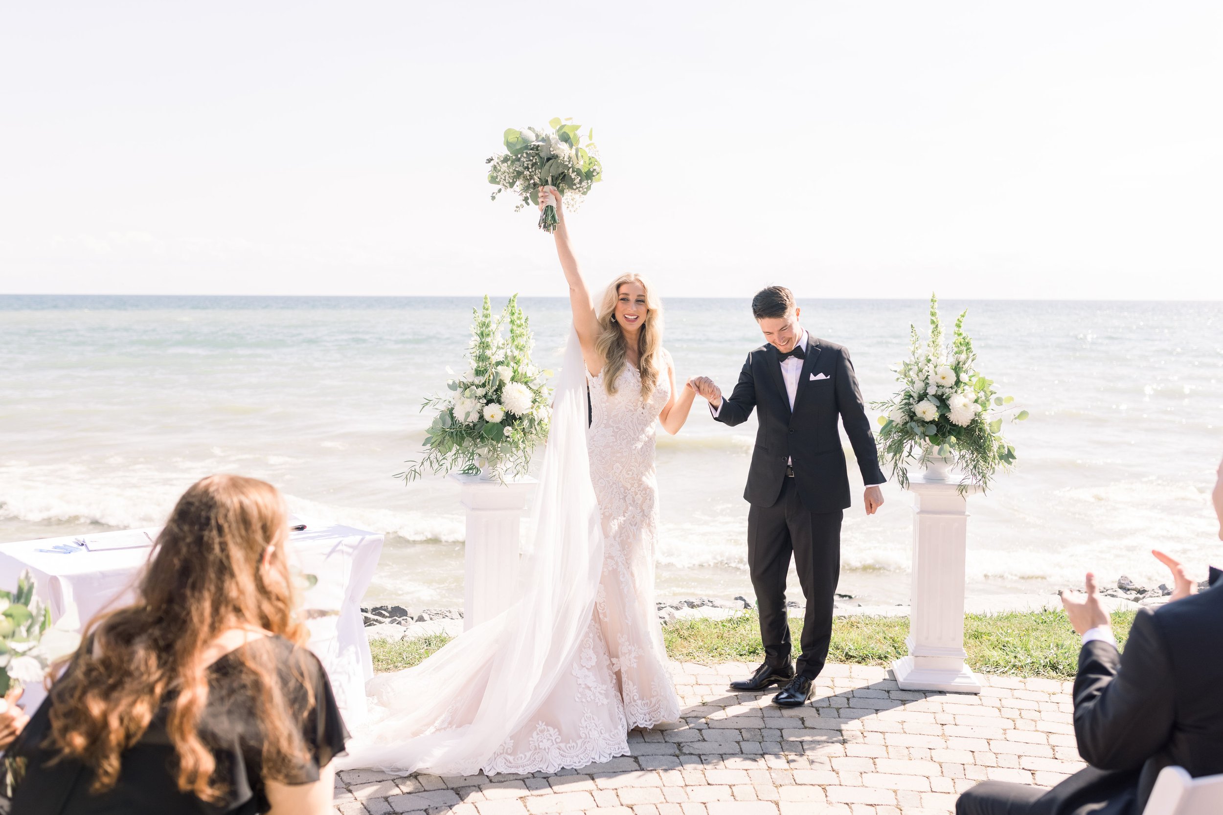  Bride cheers as a newlywed with her husband after the ceremony by Chelsea Mason Photography. newlyweds wedding vows #ChelseaMasonPhotography #ChelseaMasonWeddings #PrinceEdwardsCountyWeddings #SandbanksWeddings #ONweddingphotographer 