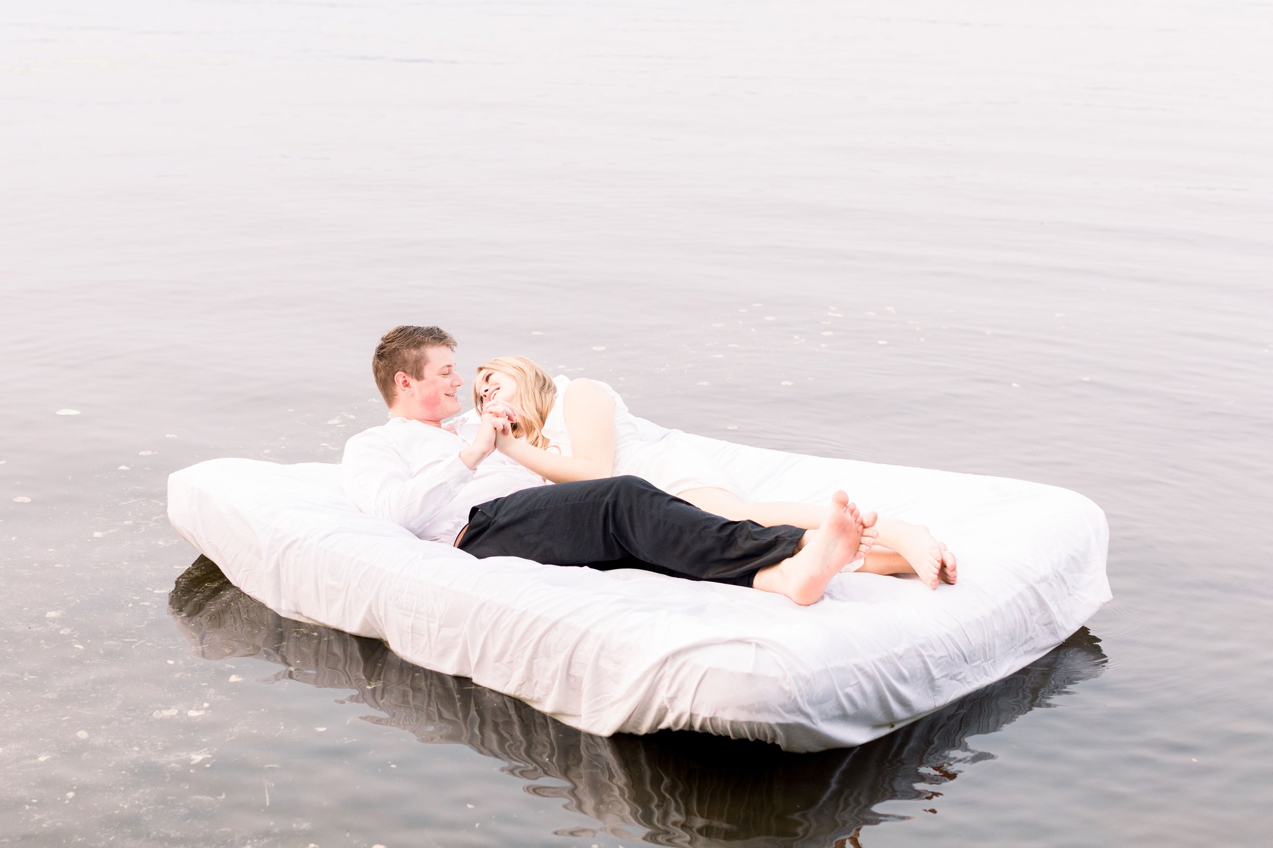  Chelsea Mason Photography captures boyfriend and girlfriend snuggling on an air mattress on a lake. fun lake engagement portraits #ChelseaMasonPhotography #ChelseaMasonEngagements #PinheysPointEngagements #OttawaEngagementPhotography 