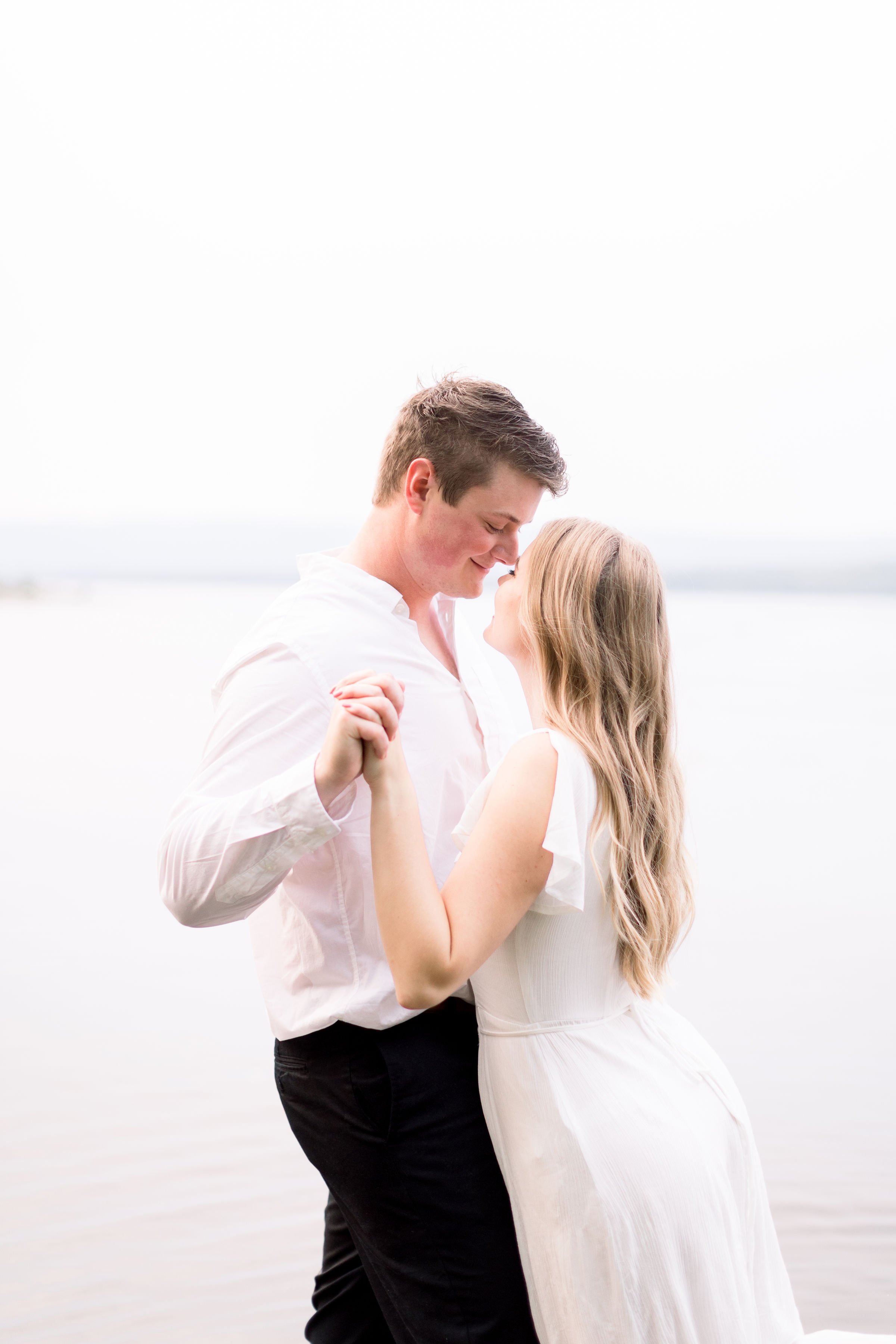  During an engagement session in Ottawa, Chelsea Mason Photography captures fiances going in for a kiss with a lake behind them. neutral wed #ChelseaMasonPhotography #ChelseaMasonEngagements #PinheysPointEngagements #OttawaEngagementPhotography 