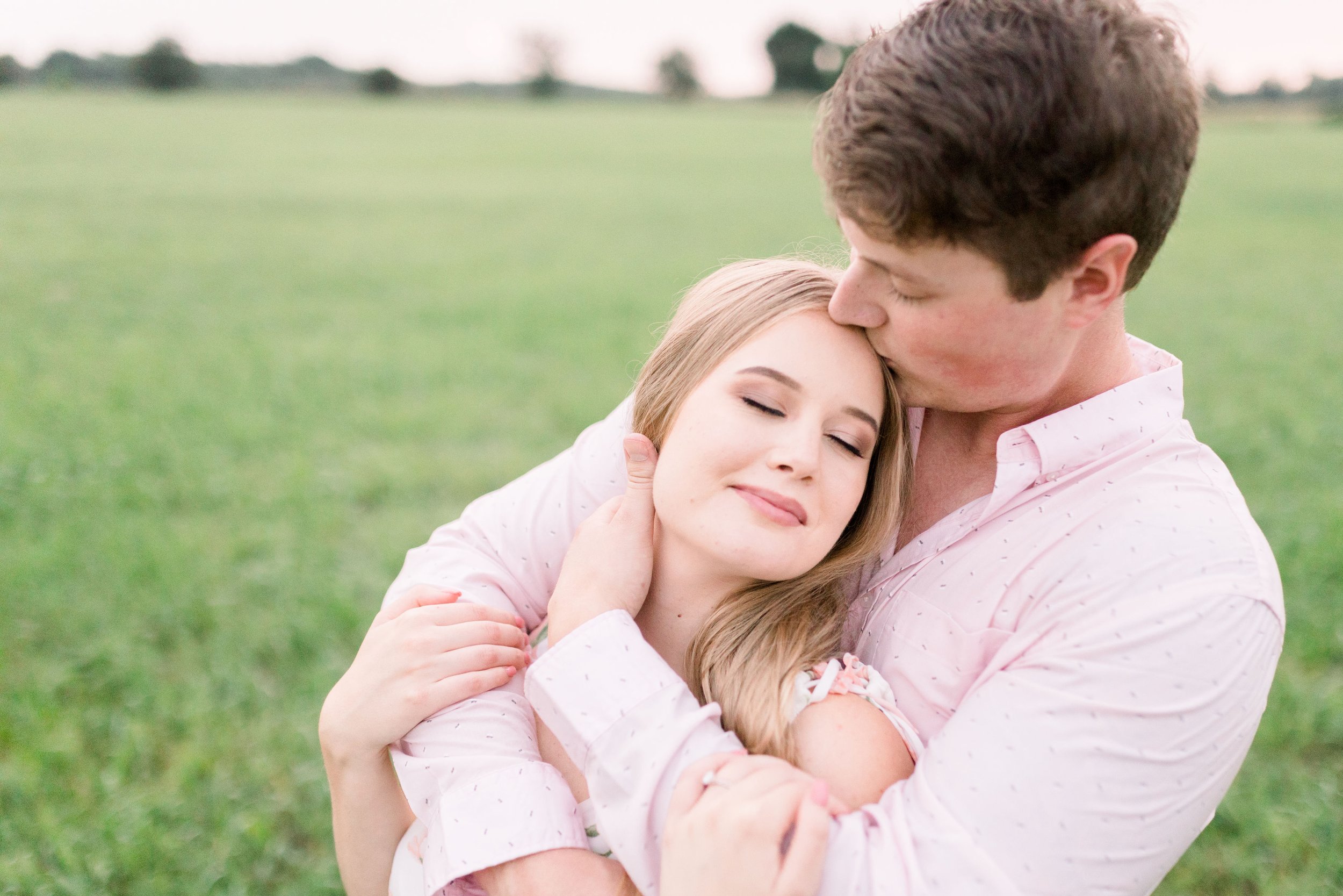  A man kisses the top of a woman's head as they snuggle together by Chelsea Mason Photography in Ottawa. engaged couple cute kissing snuggle poses #ChelseaMasonPhotography #ChelseaMasonEngagements #PinheysPointEngagements #OttawaEngagementPhotography