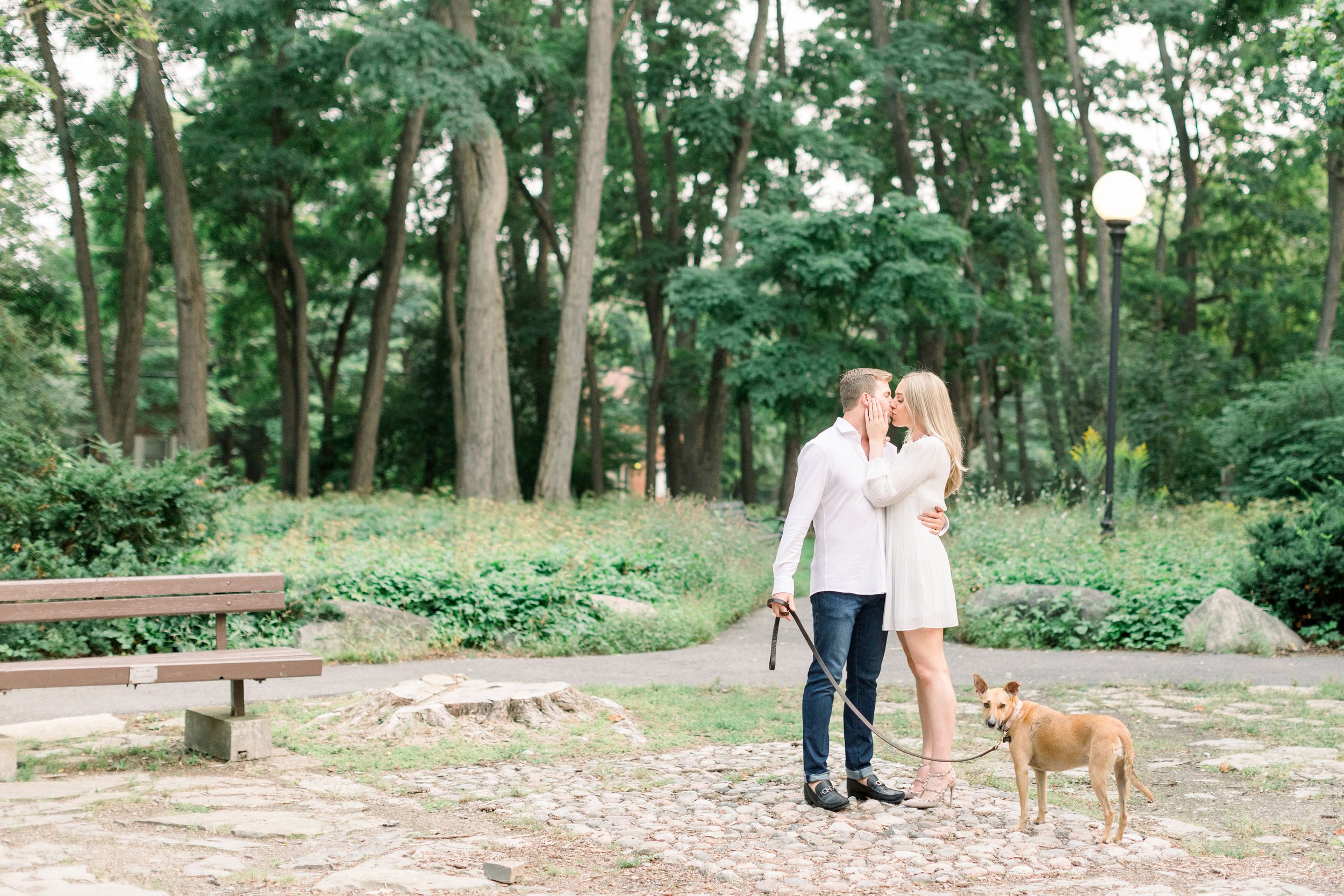  Chelsea Mason Photography captures a scenic portrait of a soon-to-be-married couple kissing in a park. nature engagement photography #Ottawaengagements #Ottawaweddingphotographers #engagementwithdogs #ChelseaMasonPhotography #ChelseaMasonEngagements