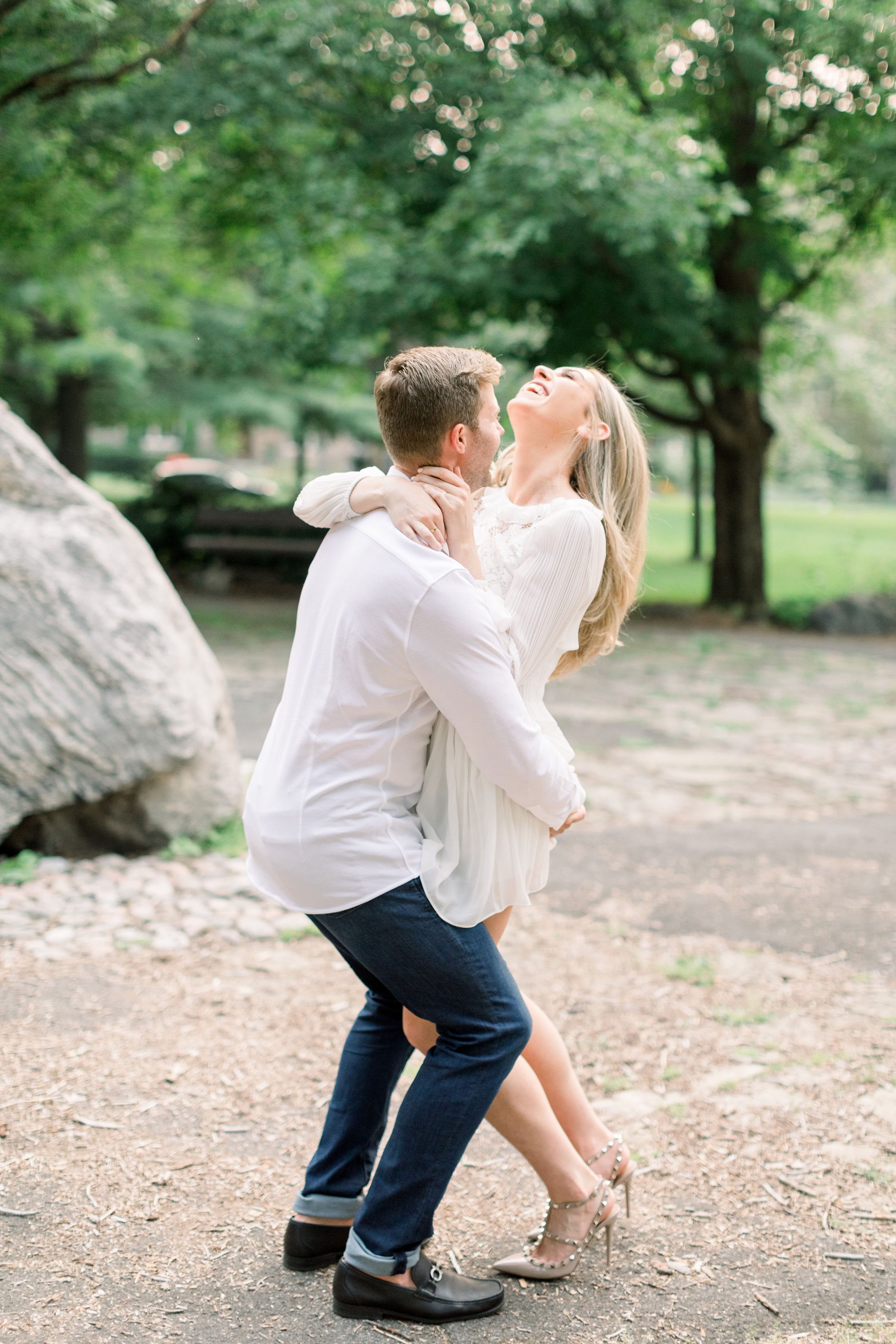  A woman laughs as a man picks her up for a playful engagement portrait by Chelsea Mason Photography. playful engagements laughing #Ottawaengagements #Ottawaweddingphotographers #engagementwithdogs #ChelseaMasonPhotography #ChelseaMasonEngagements  