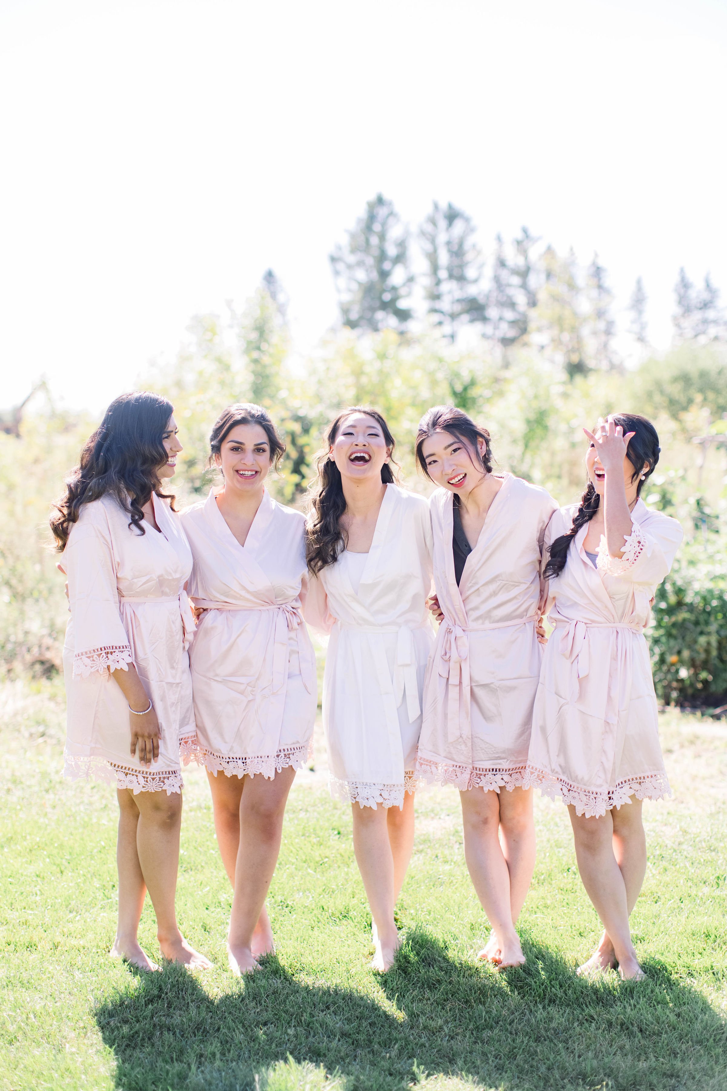  Bride laughing with her bridesmaids all wearing their robes by Chelsea Mason Photography. bride laughing with bridesmaids #ChelseaMasonPhotography #ChelseaMasonWeddings #DowntownOttawa #FairmontChateauLaurier #OttawaWeddings #OttawaPhotographers 