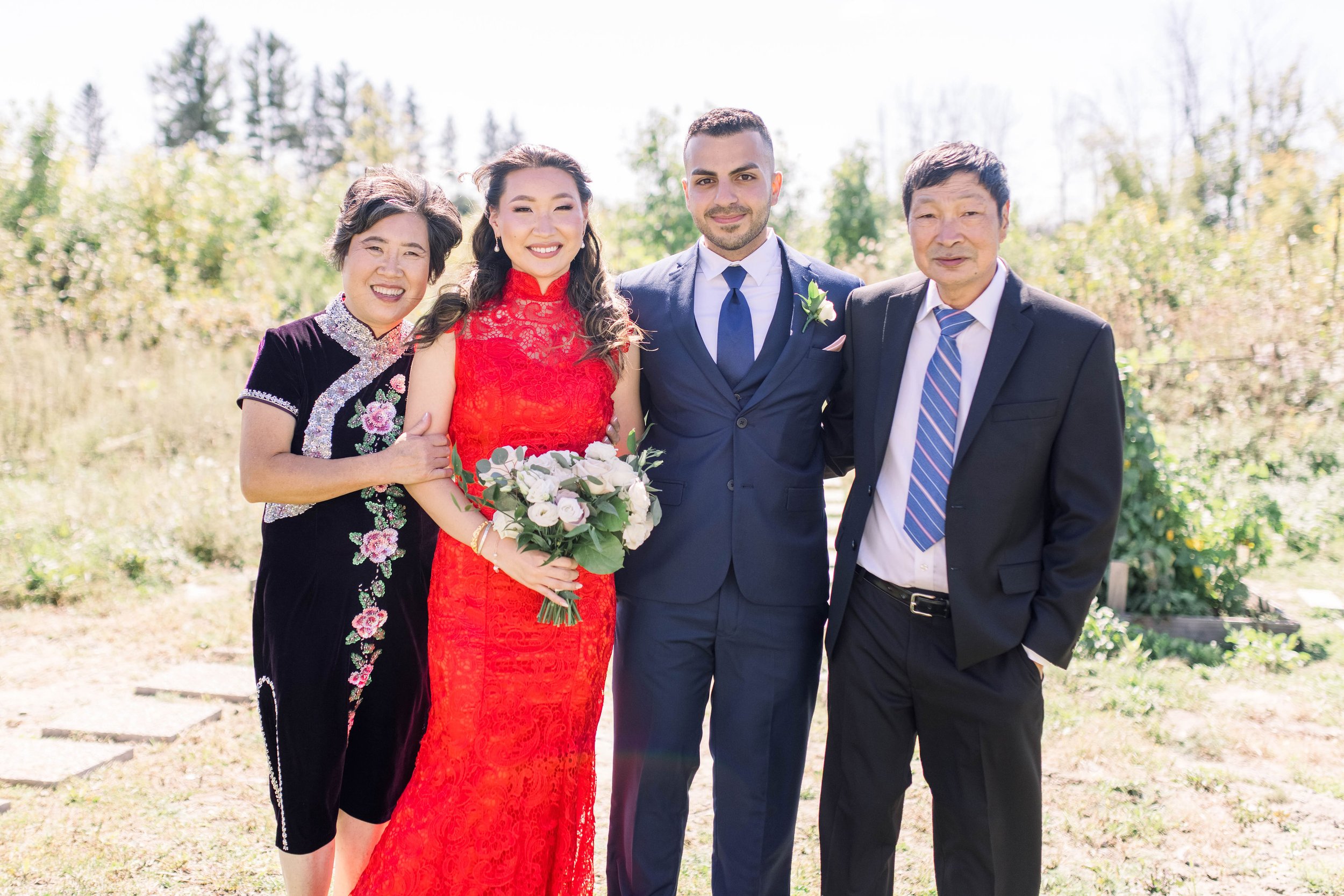  Asian bride with her family and husband wearing a red lace traditional dress by Chelsea Mason Photography. trad Asian wed #ChelseaMasonPhotography #ChelseaMasonWeddings #DowntownOttawa #FairmontChateauLaurier #OttawaWeddings #OttawaPhotographers 