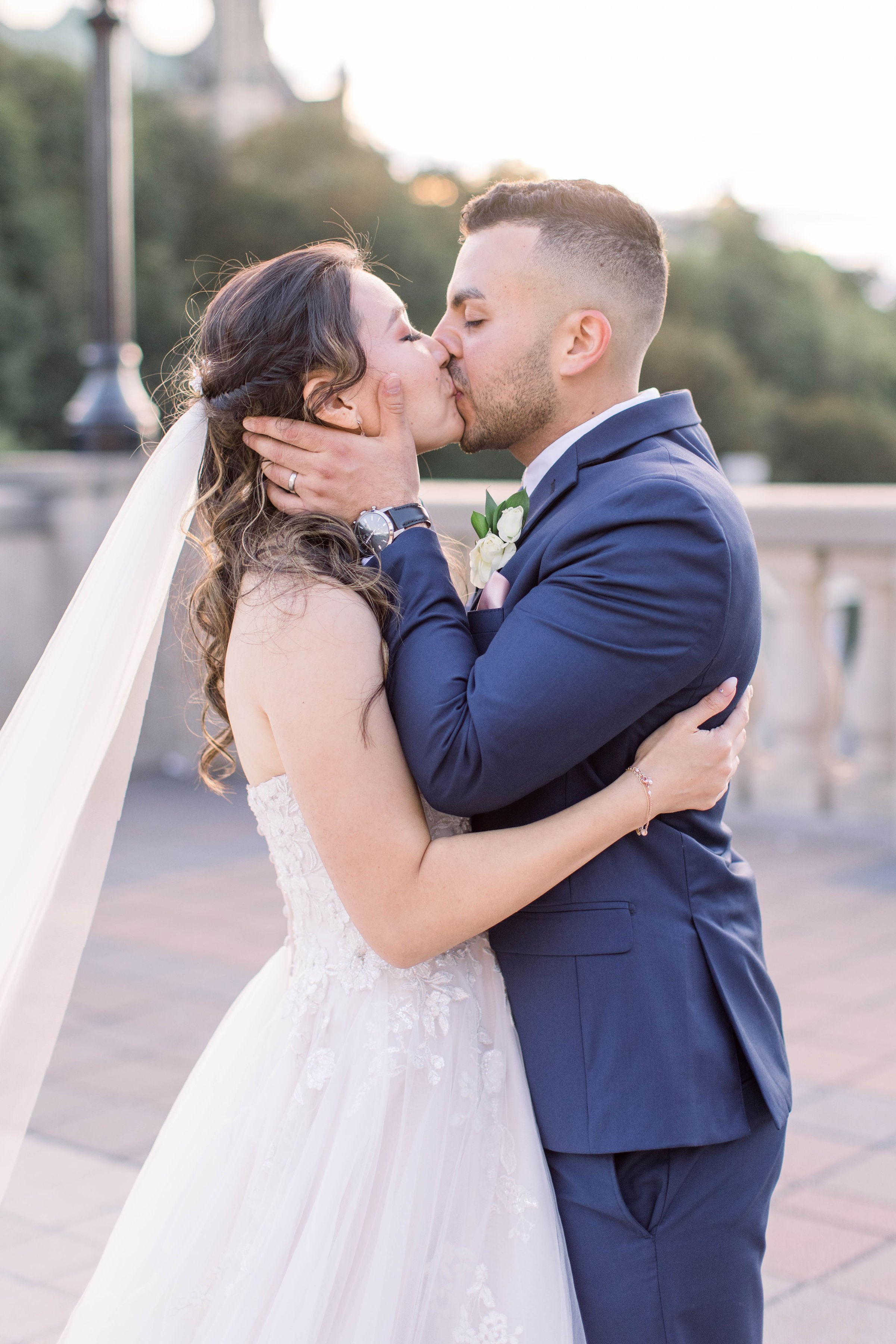  The groom kisses his bride with passion on a balcony by Chelsea Mason Photography. newlywed love Mr and Mrs blue suit #ChelseaMasonPhotography #ChelseaMasonWeddings #DowntownOttawa #FairmontChateauLaurier #OttawaWeddings #OttawaPhotographers 