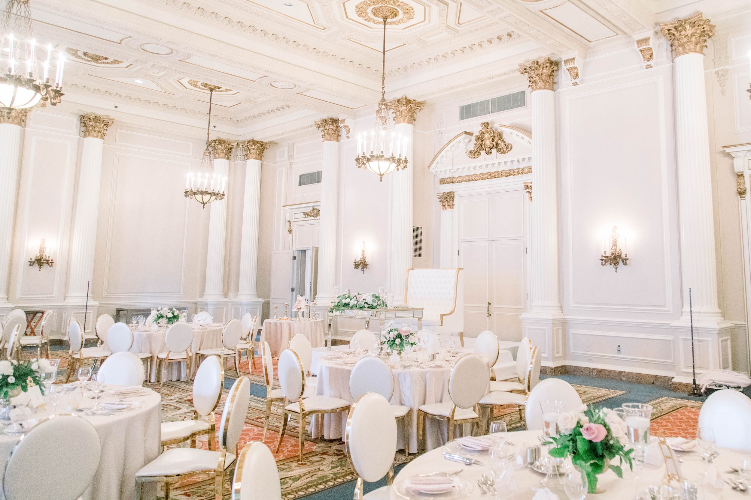  An elegant white wedding luncheon inside with chandeliers by Chelsea Mason Photography. white wedding luncheon pink florals #ChelseaMasonPhotography #ChelseaMasonWeddings #DowntownOttawa #FairmontChateauLaurier #OttawaWeddings #OttawaPhotographers 