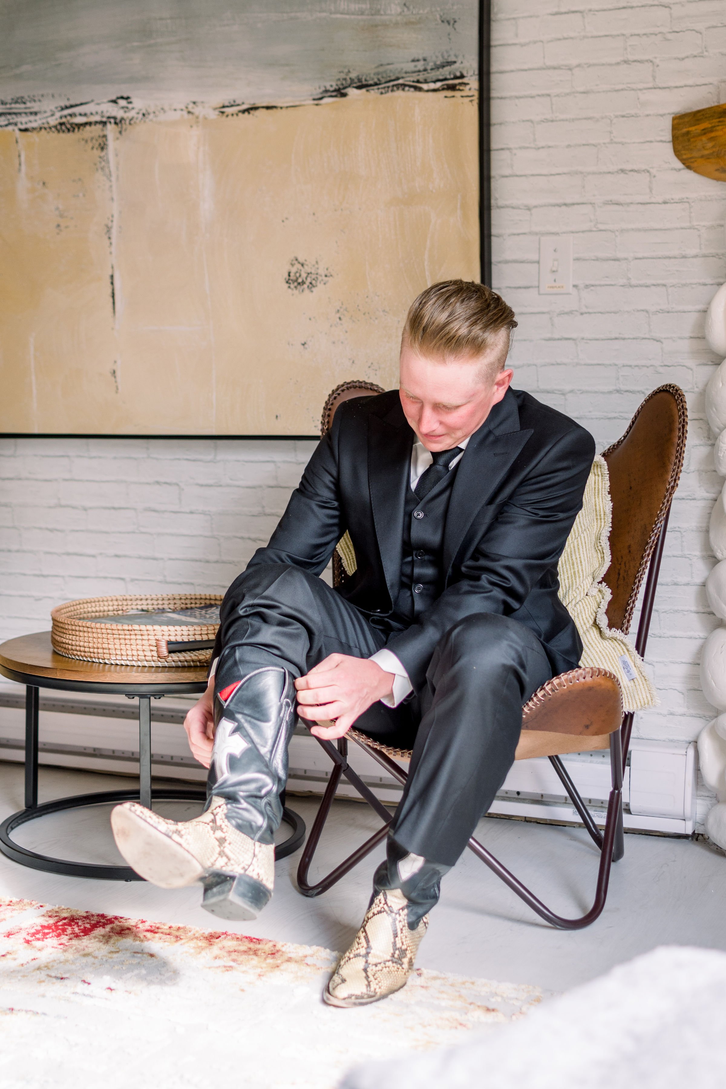  A groom puts on his cowboy boots on his wedding day at the Silvertip Golf Course by Chelsea Mason Photography. cowboy wed #Albertaweddings #shesaidyes #Albertaweddingphotographers #SilvertipGolfCourse #ChelseaMasonPhotography #ChelseaMasonWeddings  