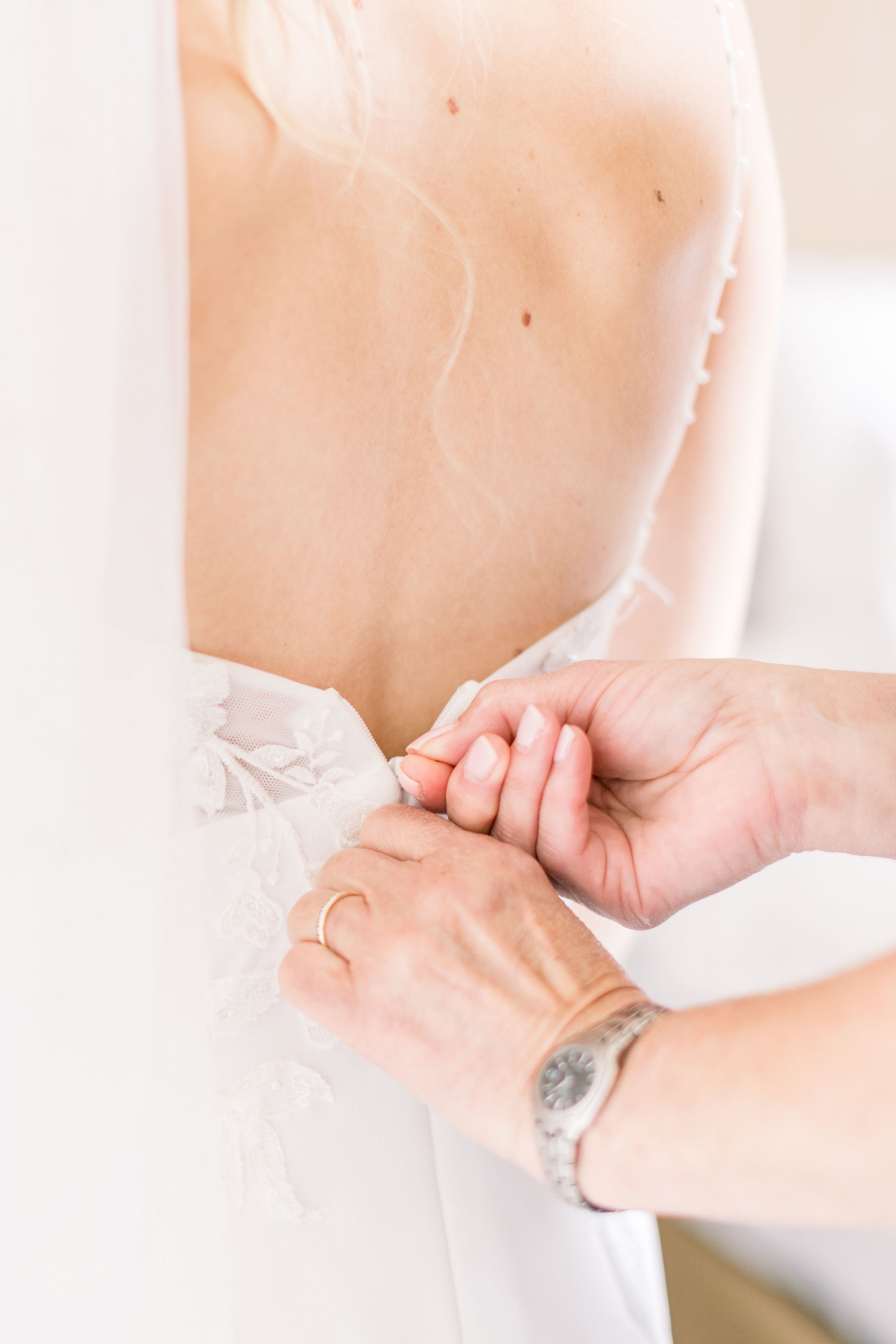  Picture of a bride getting her wedding dress zipped up by Chelsea Mason Photography during an Alberta wedding. bridal pic #Albertaweddings #shesaidyes #Albertaweddingphotographers #SilvertipGolfCourse #ChelseaMasonPhotography #ChelseaMasonWeddings  