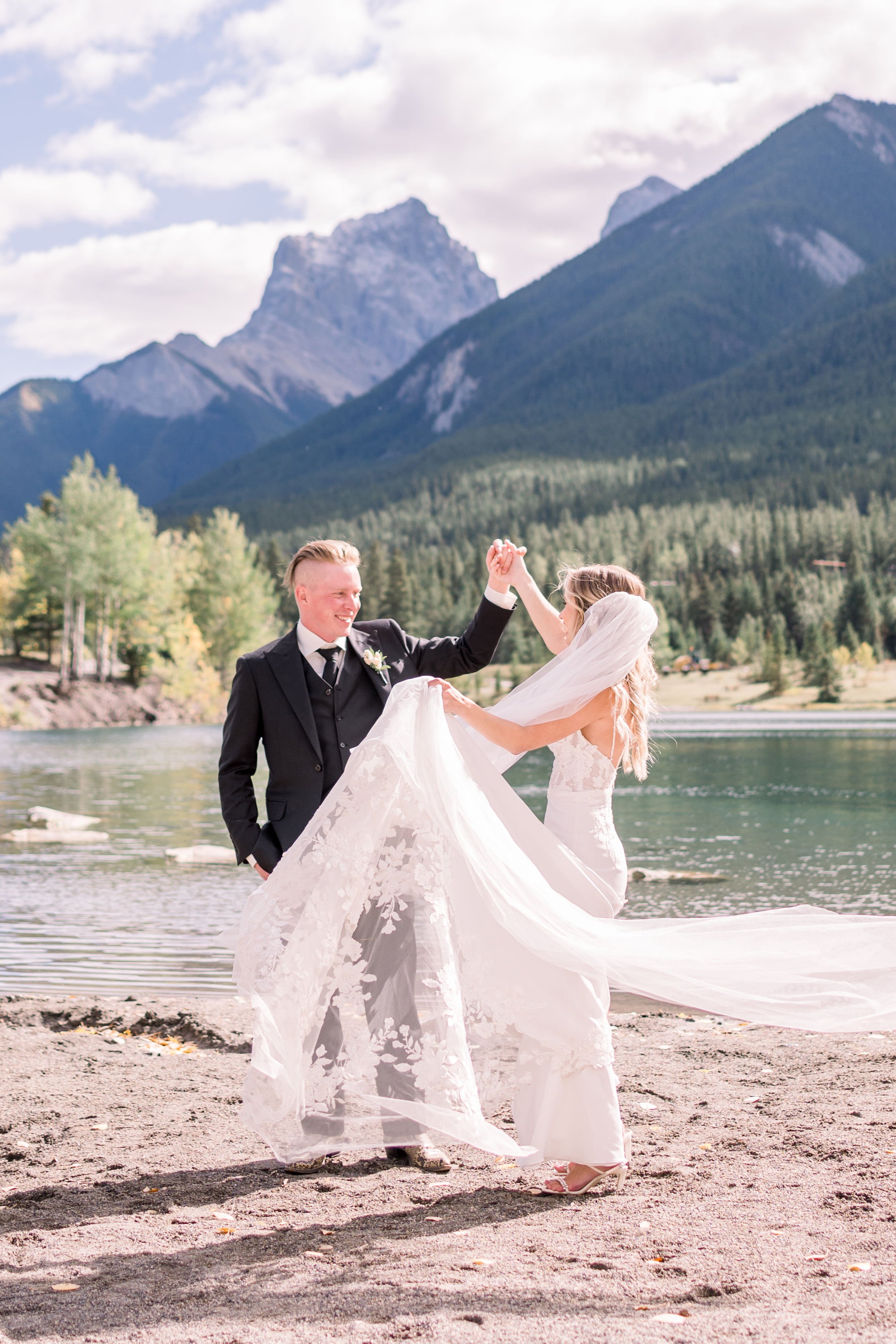  Chelsea Mason Photography captures a bride and groom dancing on a mountain next to a lake. summer weddings in Canada #Albertaweddings #shesaidyes #Albertaweddingphotographers #SilvertipGolfCourse #ChelseaMasonPhotography #ChelseaMasonWeddings  