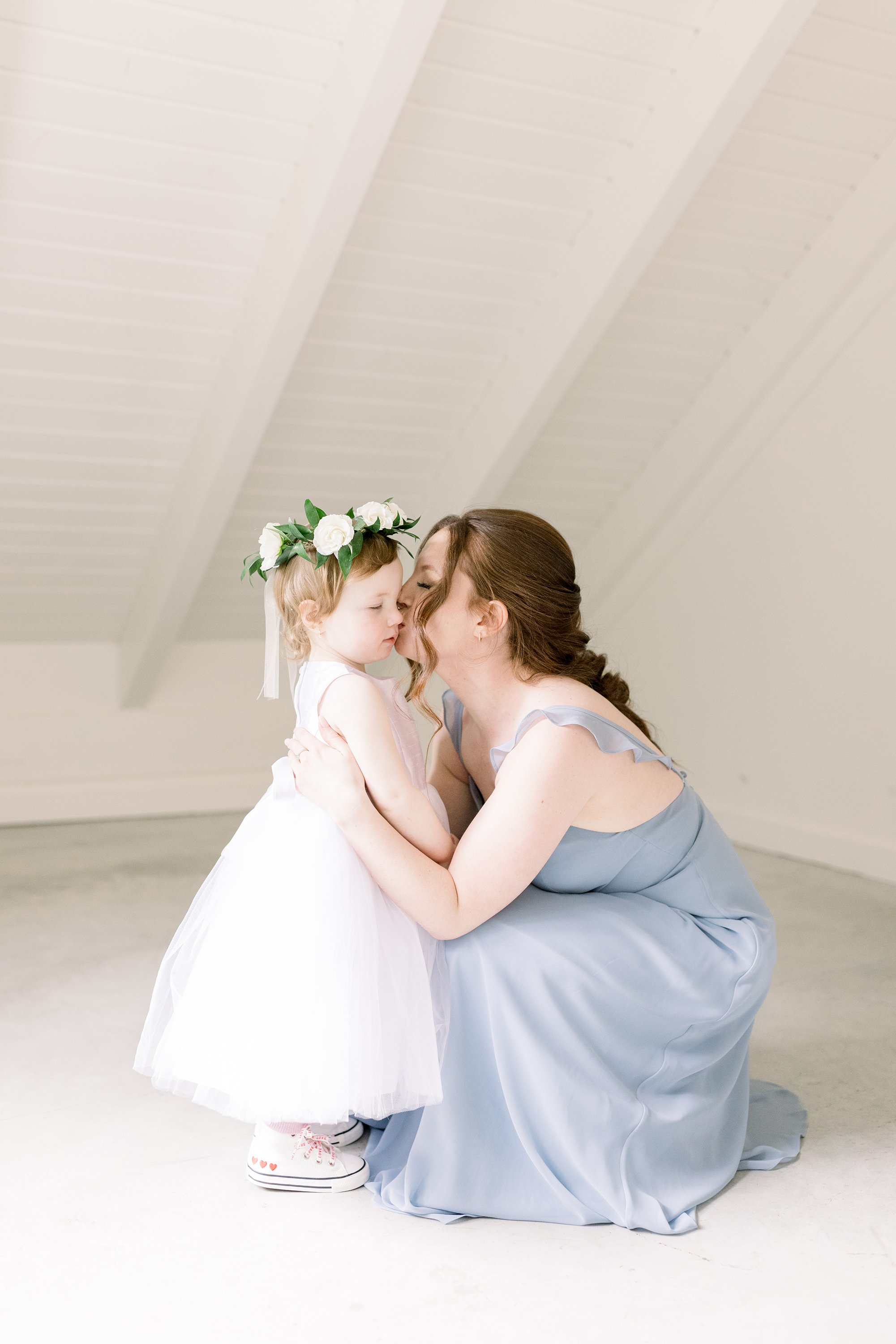  The maid of honor kisses the cheek of the flower girl by Chelsea Mason Photography in Le Belvedere. maid of honor and flower girl #ChelseaMasonPhotography #ChelseaMasonWeddings #WakefieldWeddings #LeBelvedere #Wakefieldweddingphotographers 