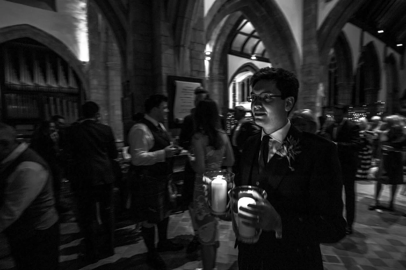 GROOM-CARRIES-CANDLES-CHURCH.jpg