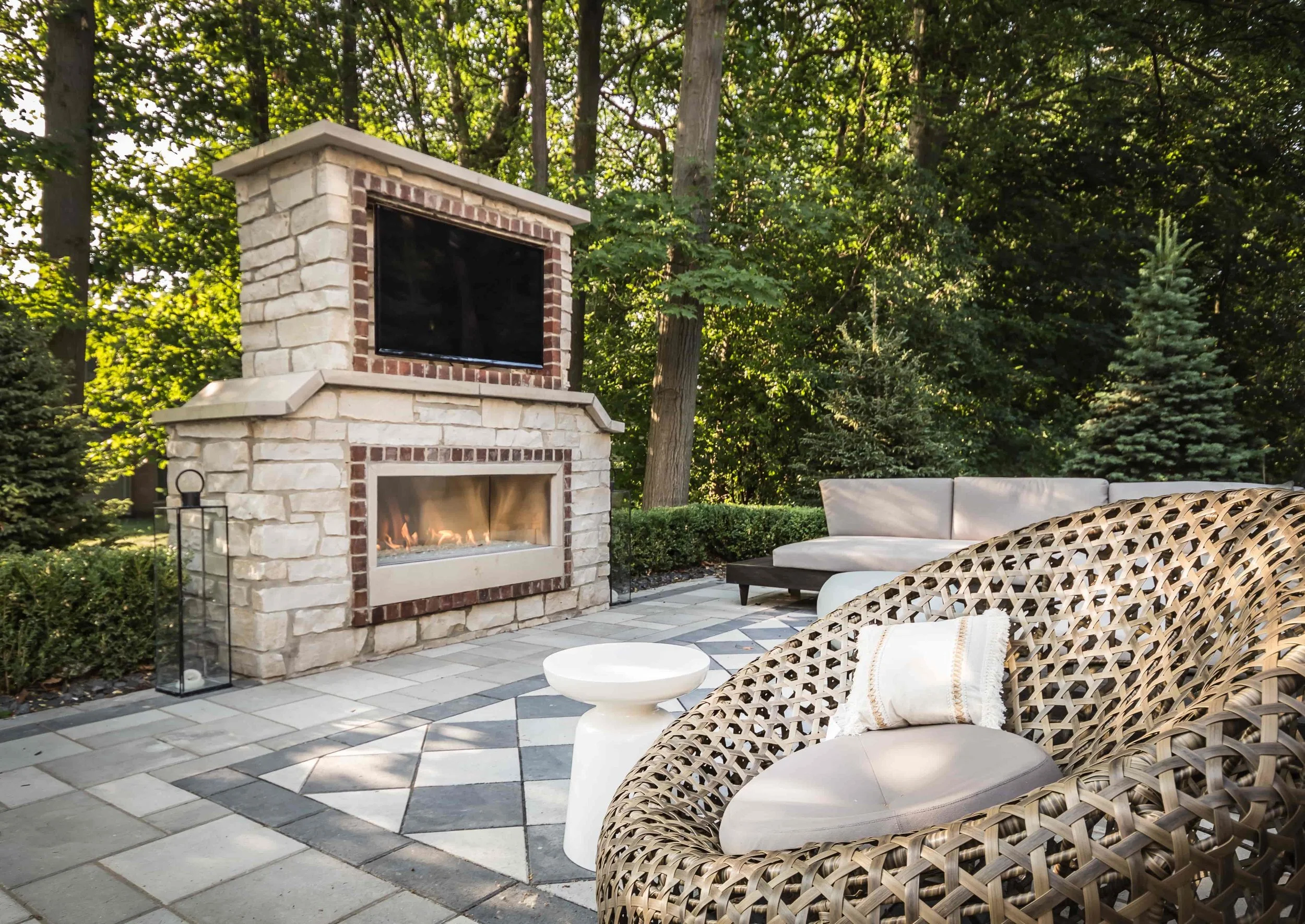 Outdoor living space with custom outdoor fireplace with mounted all weather TV