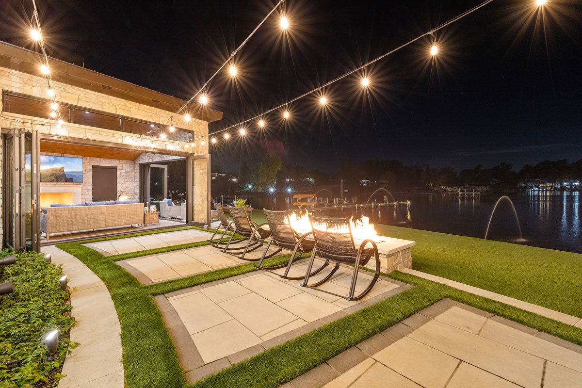 10 foot gas fueled fire pit overlooks the lake with market lights strung overhead
