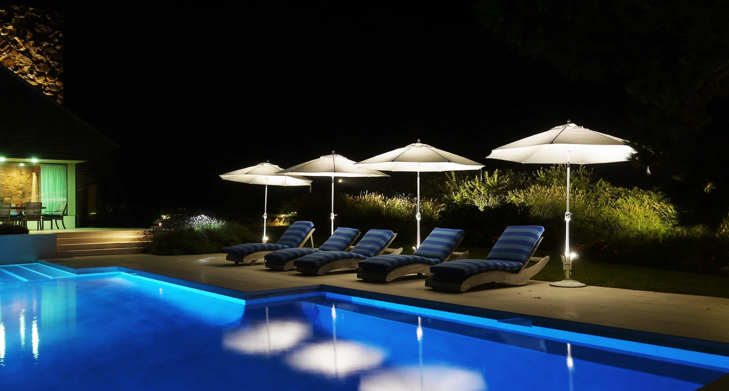 Evening garden lighting at Southampton Hamptons estate — warm landscape lighting across garden and lawn at night