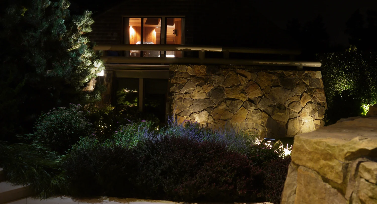 Pathway lighting at Southampton estate — glowing lit walkway through manicured Hamptons garden at night