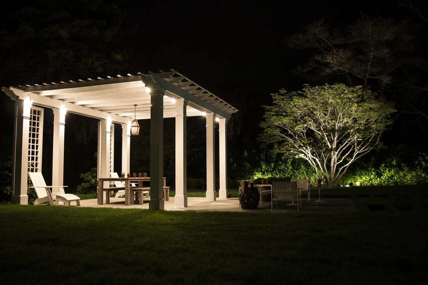 Pergola lighting at Watermill Hamptons estate — integrated outdoor lighting on outdoor structure at night
