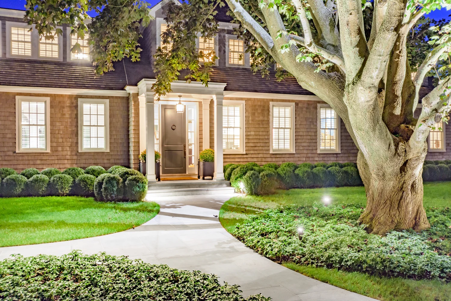 Summer evening lighting at Southampton Hamptons estate — warm outdoor lighting in lush summer garden