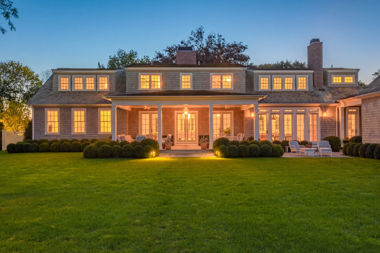 Illuminated garden beds at Southampton Hamptons estate — layered lighting highlighting planting arrangements