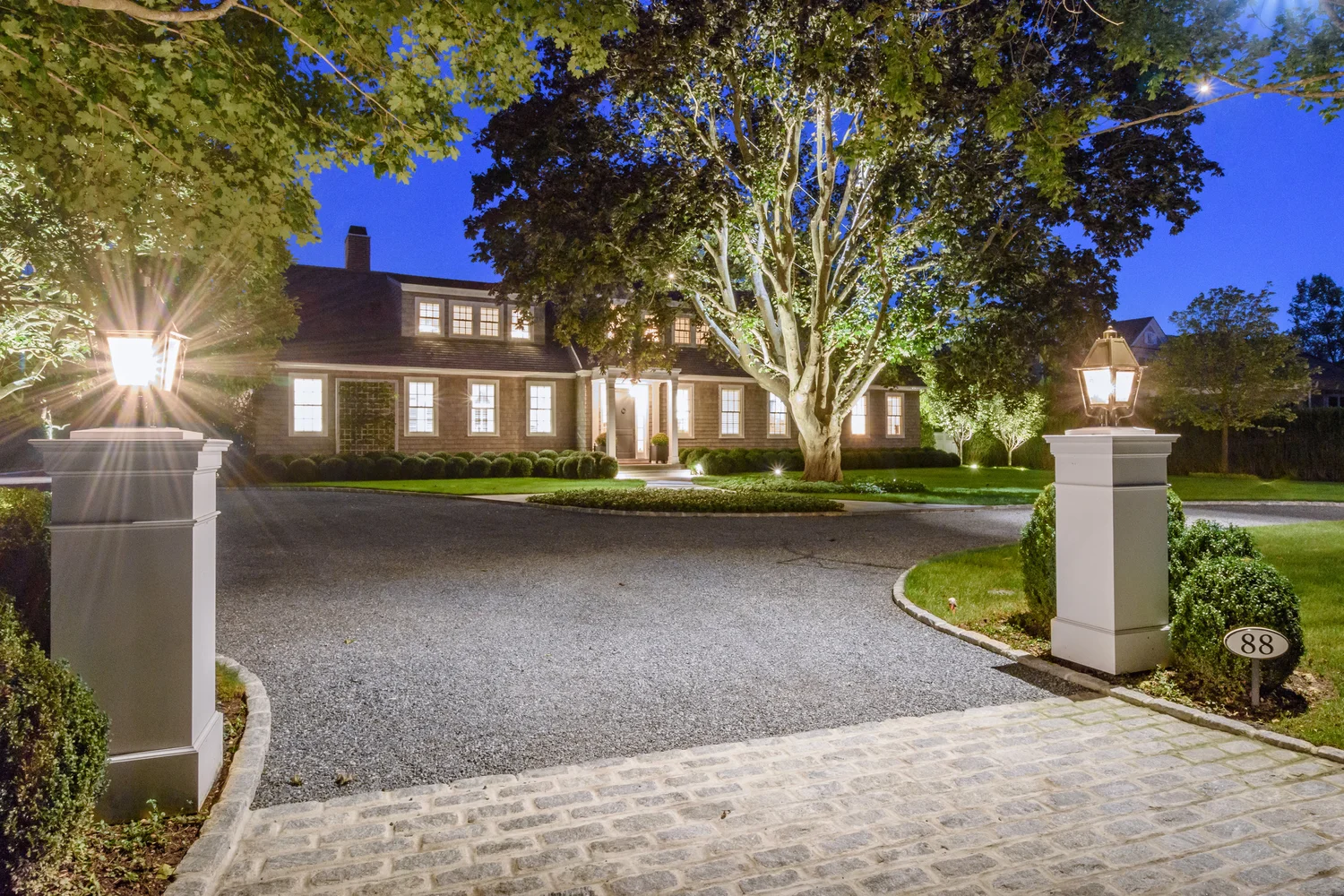 Evening lighting at Southampton Hamptons estate — warm outdoor lighting across property at night