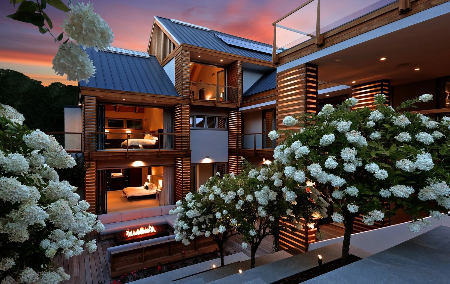 Landscape lighting project designed by Vanessa Kordich — trees illuminated at dusk at Sagaponack Hamptons estate