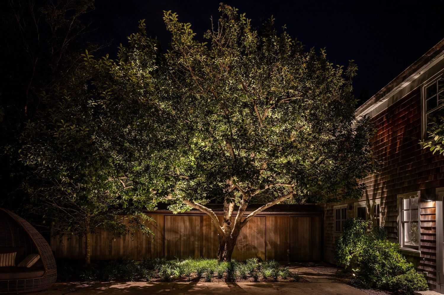 Architectural lighting detail at Amagansett estate — precision fixture aiming on garden features