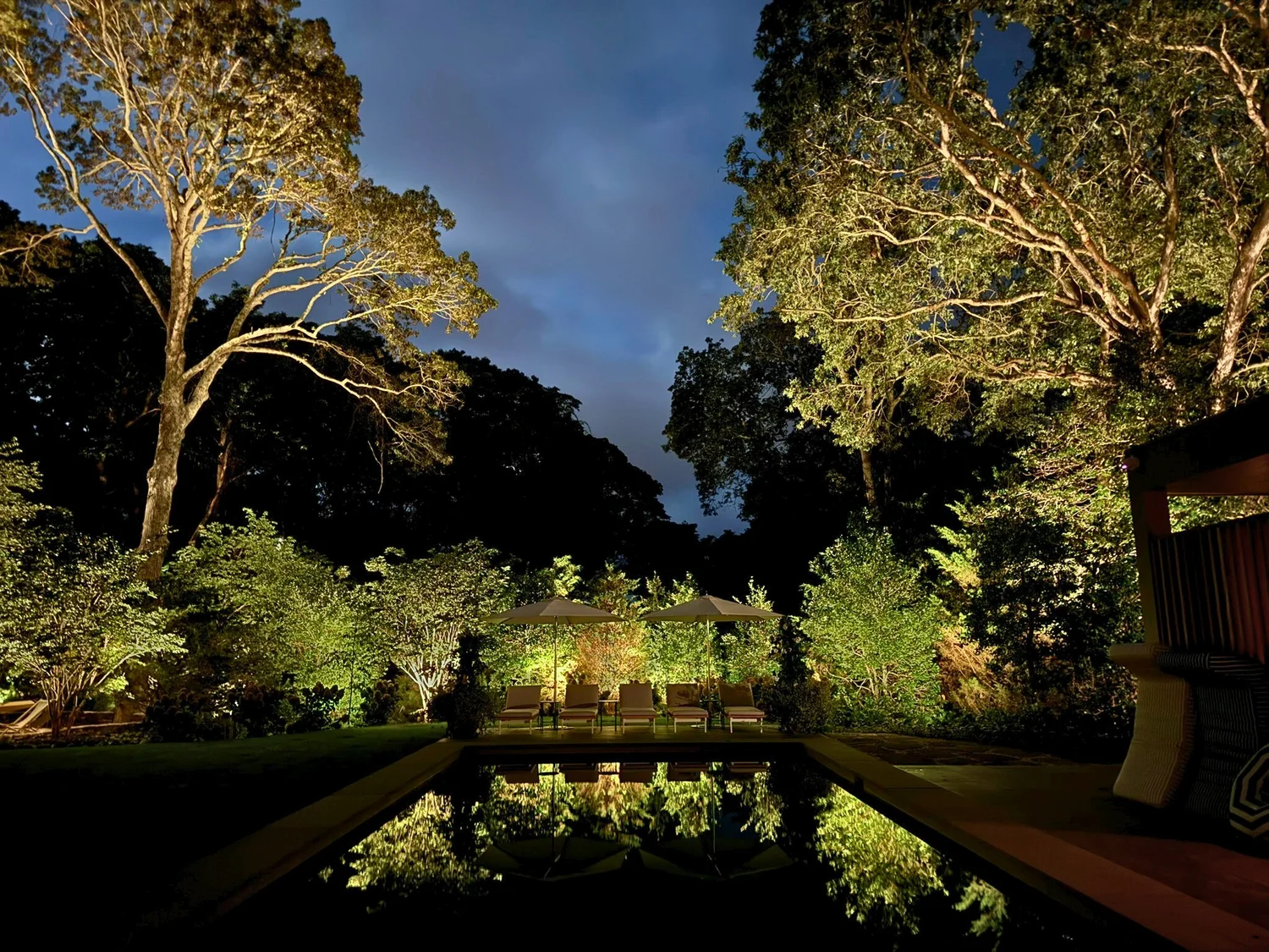 Pool area lighting at Amagansett Hamptons estate — ambient lighting around pool deck and landscaping