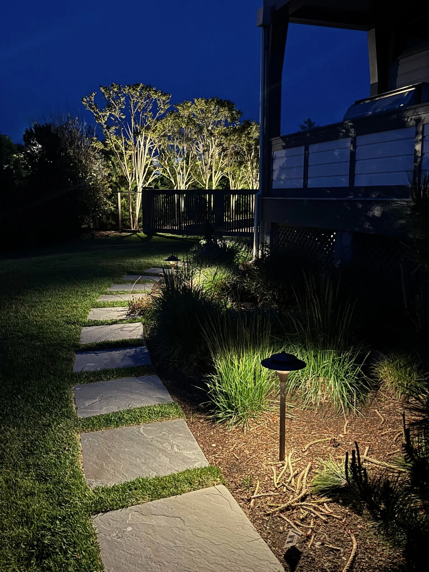 Pathway lighting at Westhampton Hamptons property — softly lit walkway through garden landscape