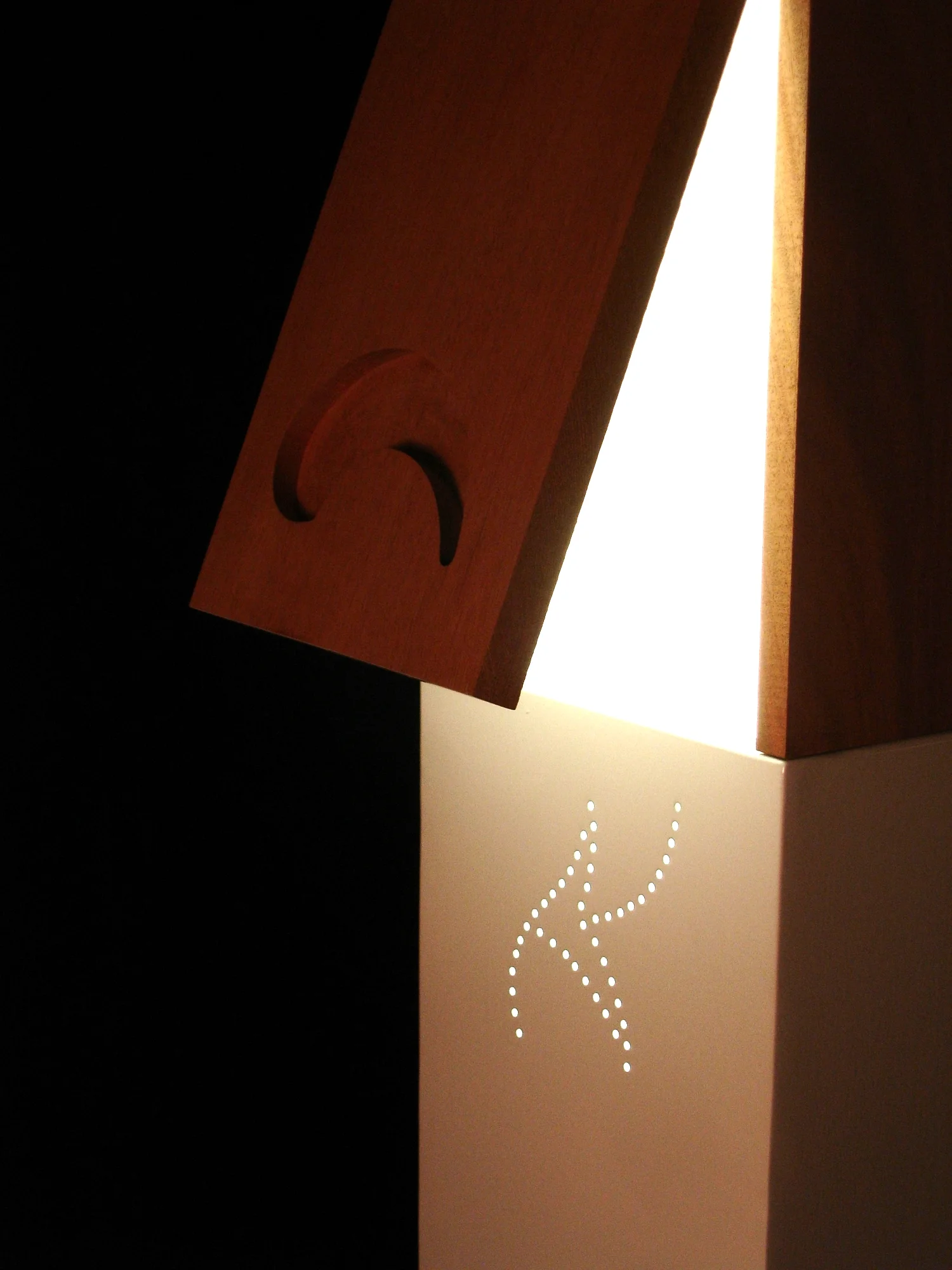 The Woodwhite lamp integrates a lamp’s necessary function of providing light with creative operational solutions. For example, the grooved pattern in the wood acts as both an aesthetic detail and handle, due to the inward routed angle of the organic pattern. Additionally, a hidden magnetically controlled switch turns on the lights when the wooden hatch doors are opened and turned off when closed.