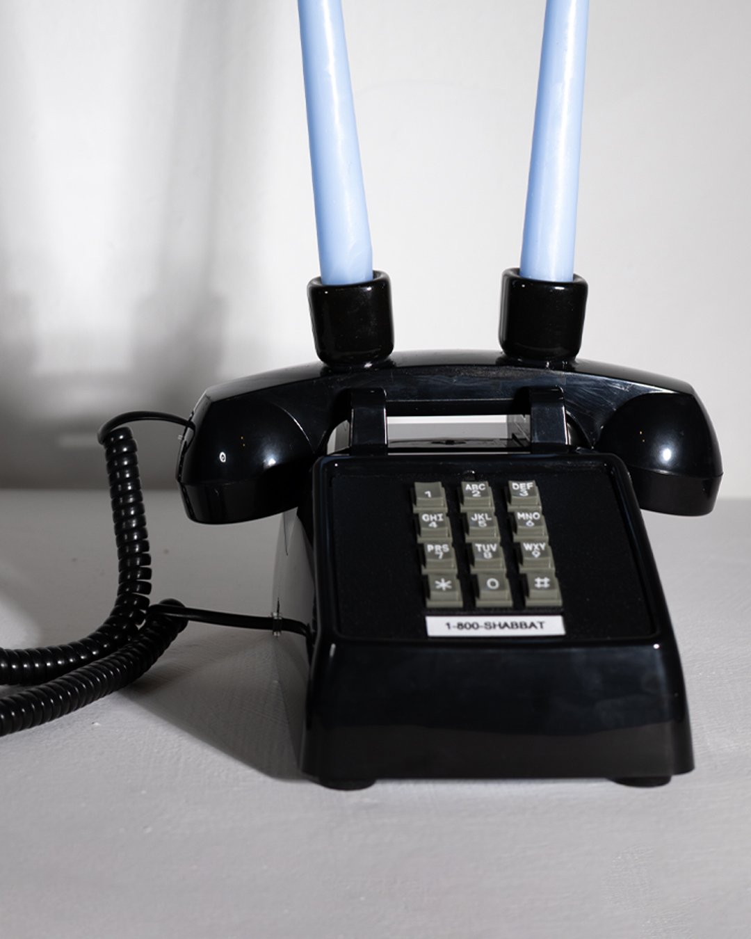  THE 1-800-SHABBAT PHONE  (black edition)  9.12 x 7.26 x 4.67 inches  Acrylonitrile Butadiene Styrene (ABS)+Metal Base  Ceramic candle holders  2026 