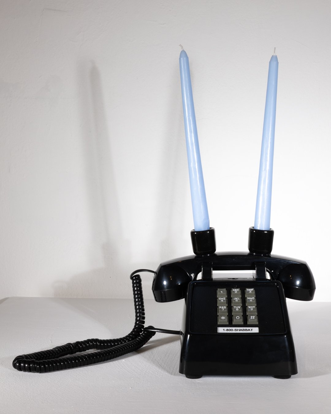  THE 1-800-SHABBAT PHONE  (black edition)  9.12 x 7.26 x 4.67 inches  Acrylonitrile Butadiene Styrene (ABS)+Metal Base  Ceramic candle holders  2026 