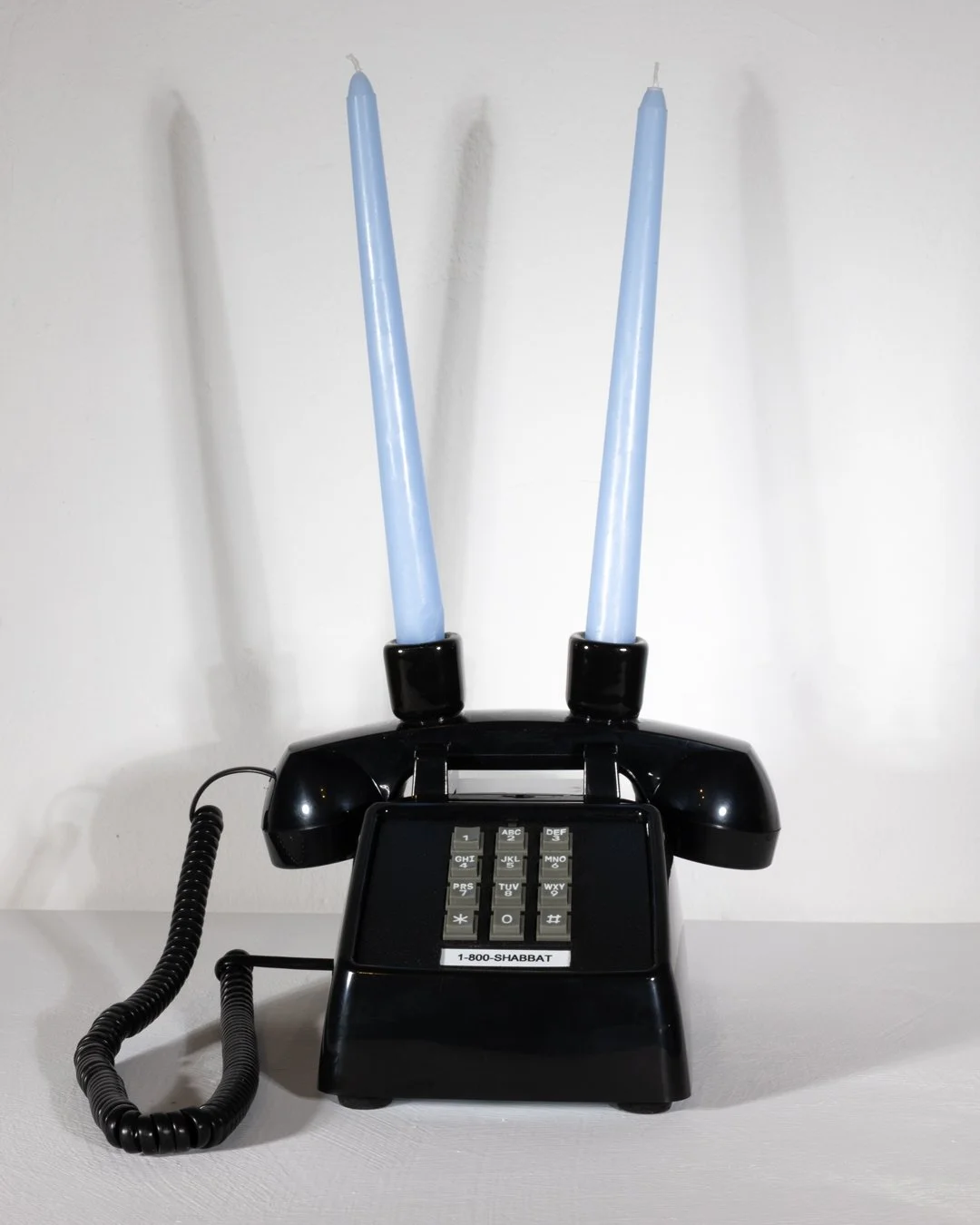  THE 1-800-SHABBAT PHONE  (black edition)  9.12 x 7.26 x 4.67 inches  Acrylonitrile Butadiene Styrene (ABS)+Metal Base  Ceramic candle holders  2026 