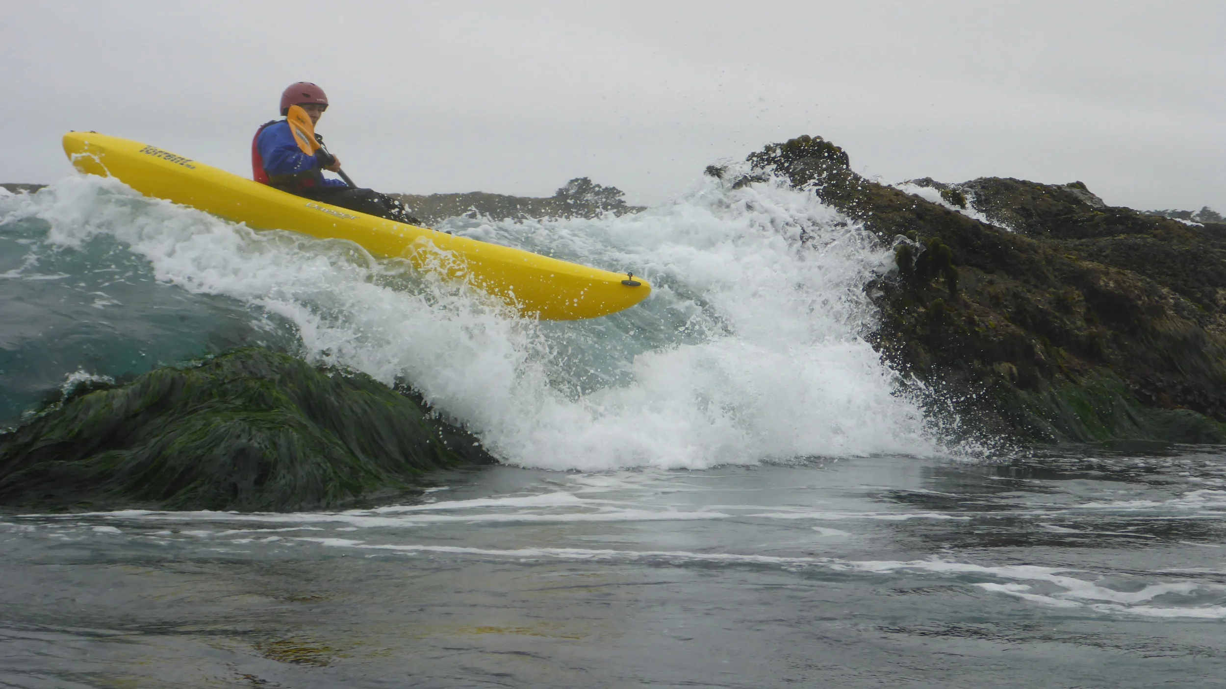 A beginning kayaker rock gardening on the Mendocino Coast.
