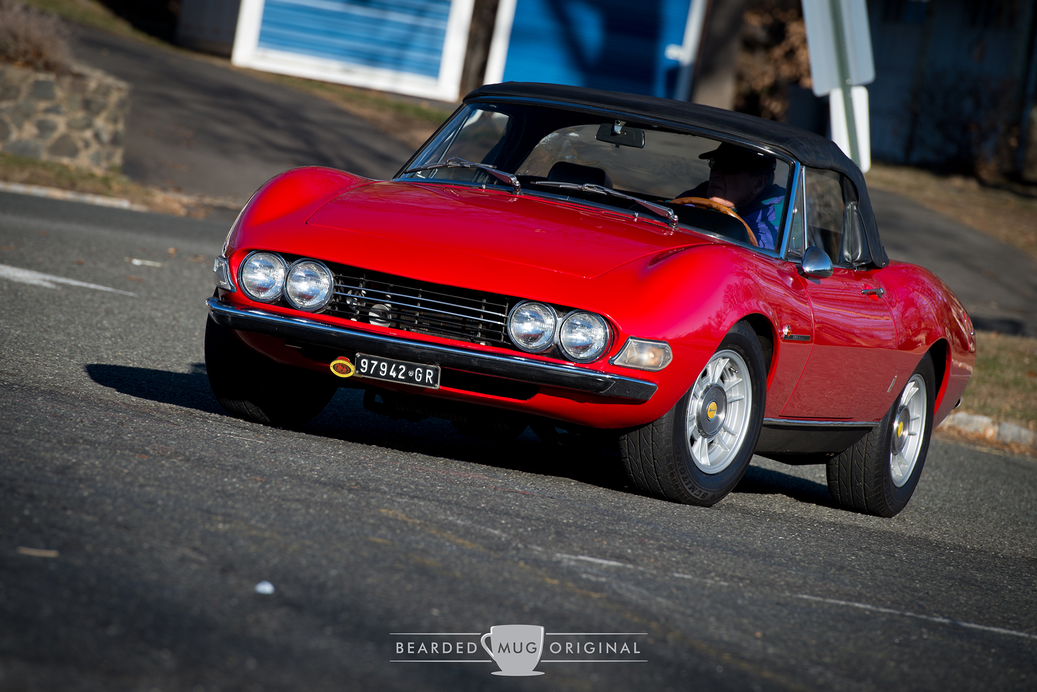 A Fiat Dino enters the parking lot of the local Cars and Croissants.