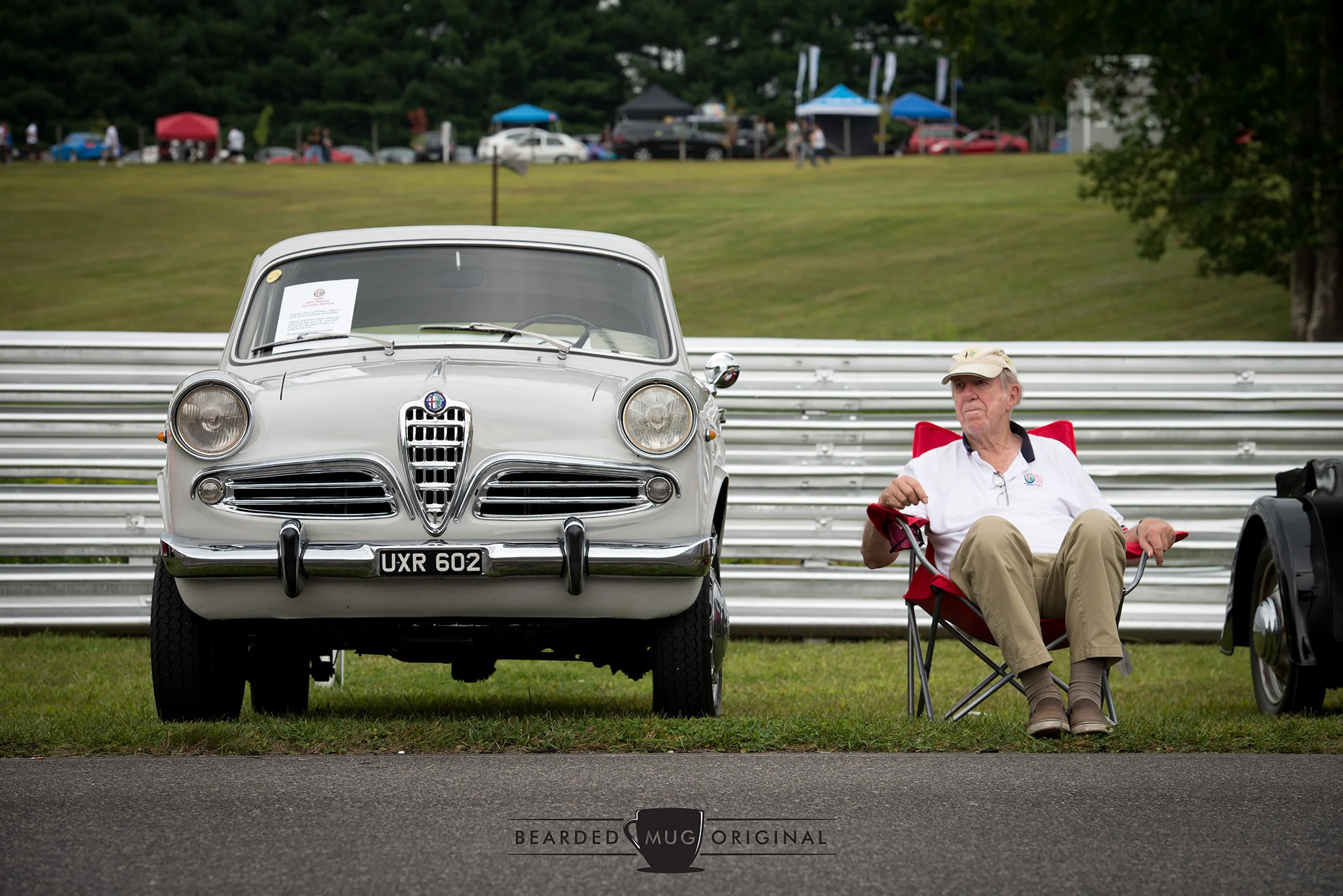 The presumed owner of this 1960 Alfa Romeo Giulietta Berlina enjoys a relaxing bit of time next a all-original Italian classic.