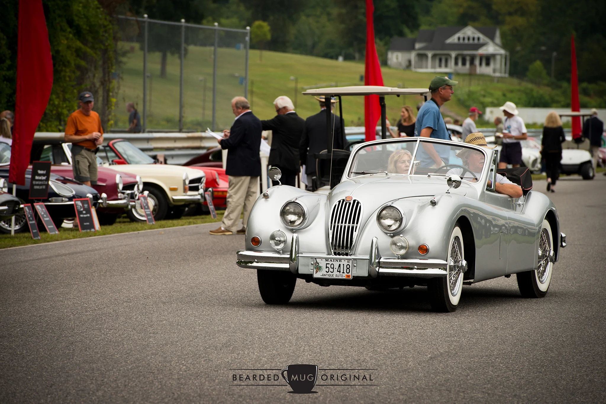 A beautiful Jaguar XK140 Drophead Coupe scans for parking in its appropriate class.