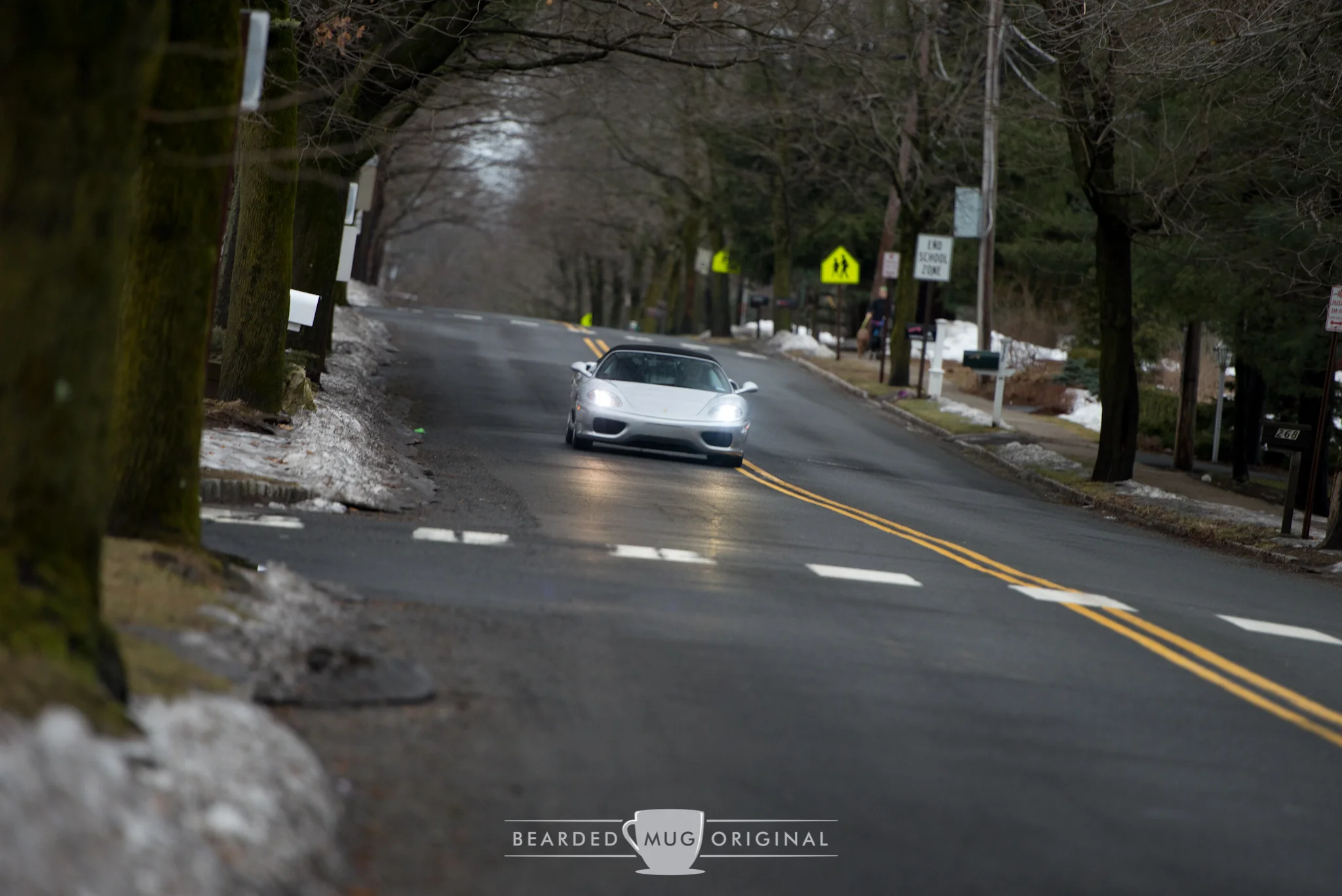 The damp road is visible by the reflection of this F360 Spider's headlights on the pavement.