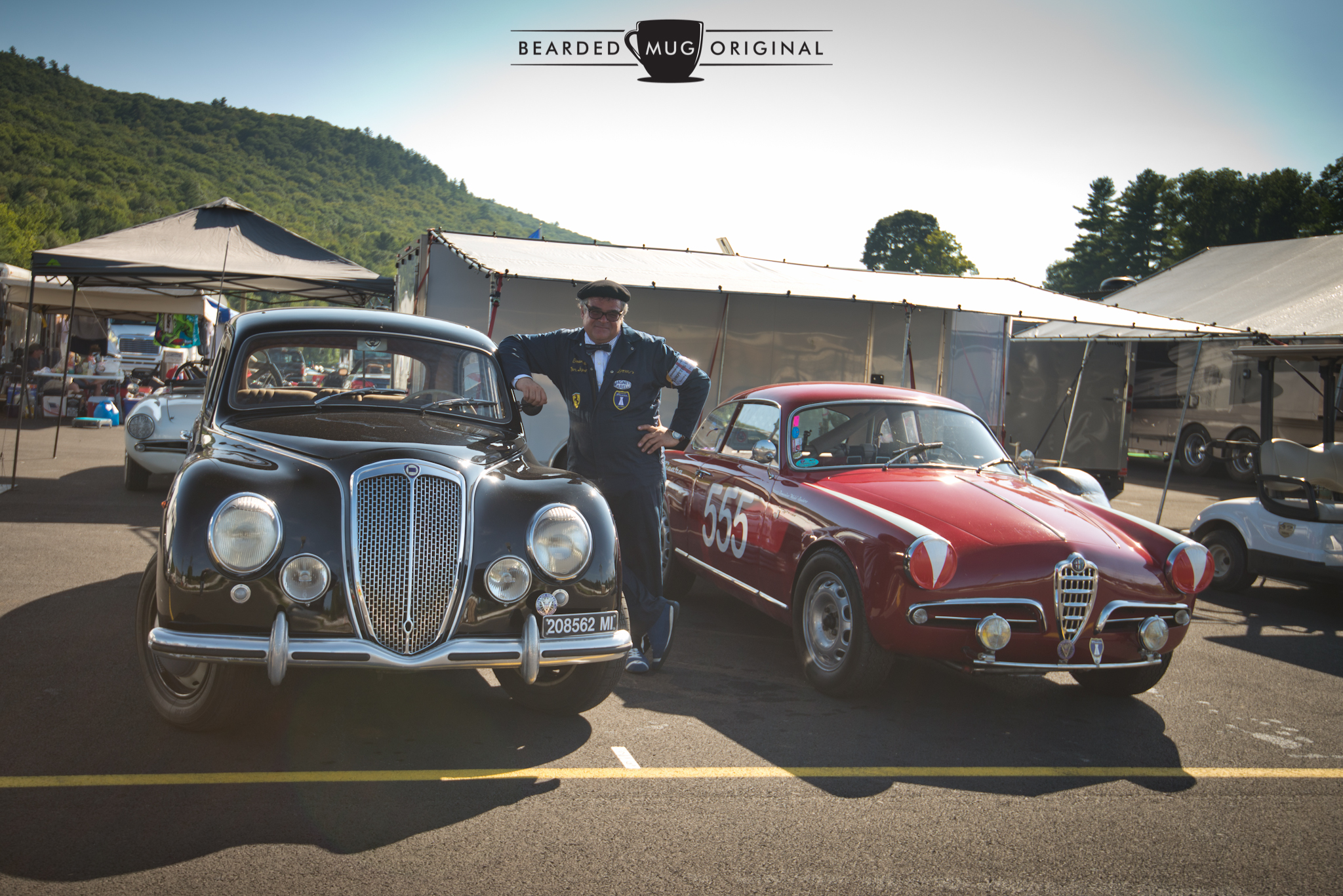 Santo, dressed in his father's period-correct garb, stands proudly between his 1953 Lancia Aurelia B10S and the featured Alfa.