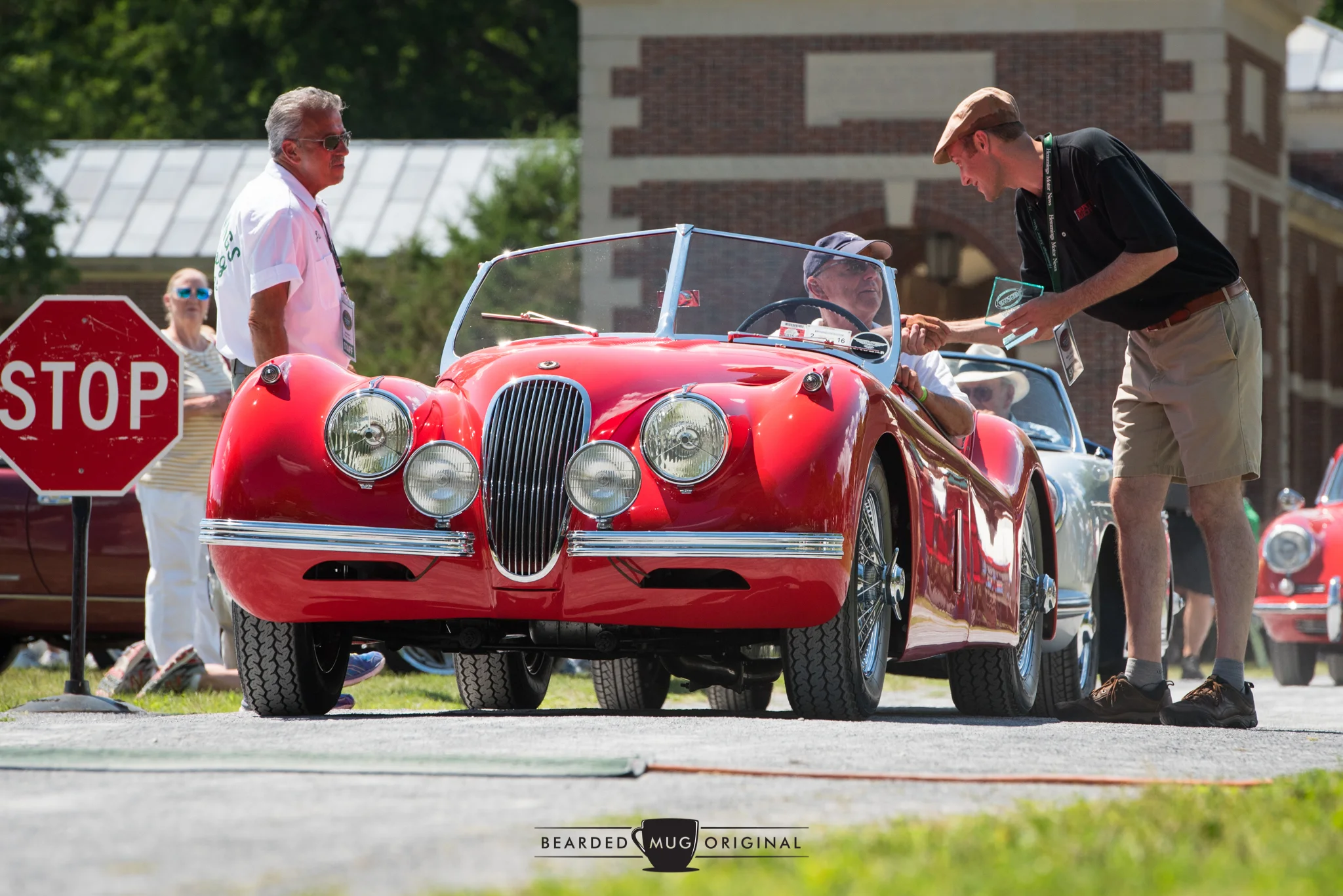Publisher Jim Menneto (l.) and Mark J. McCourt (r.) present this beautiful Jaguar XK120 with a well-deserved award at the 2016 Sports & Exotic Show.